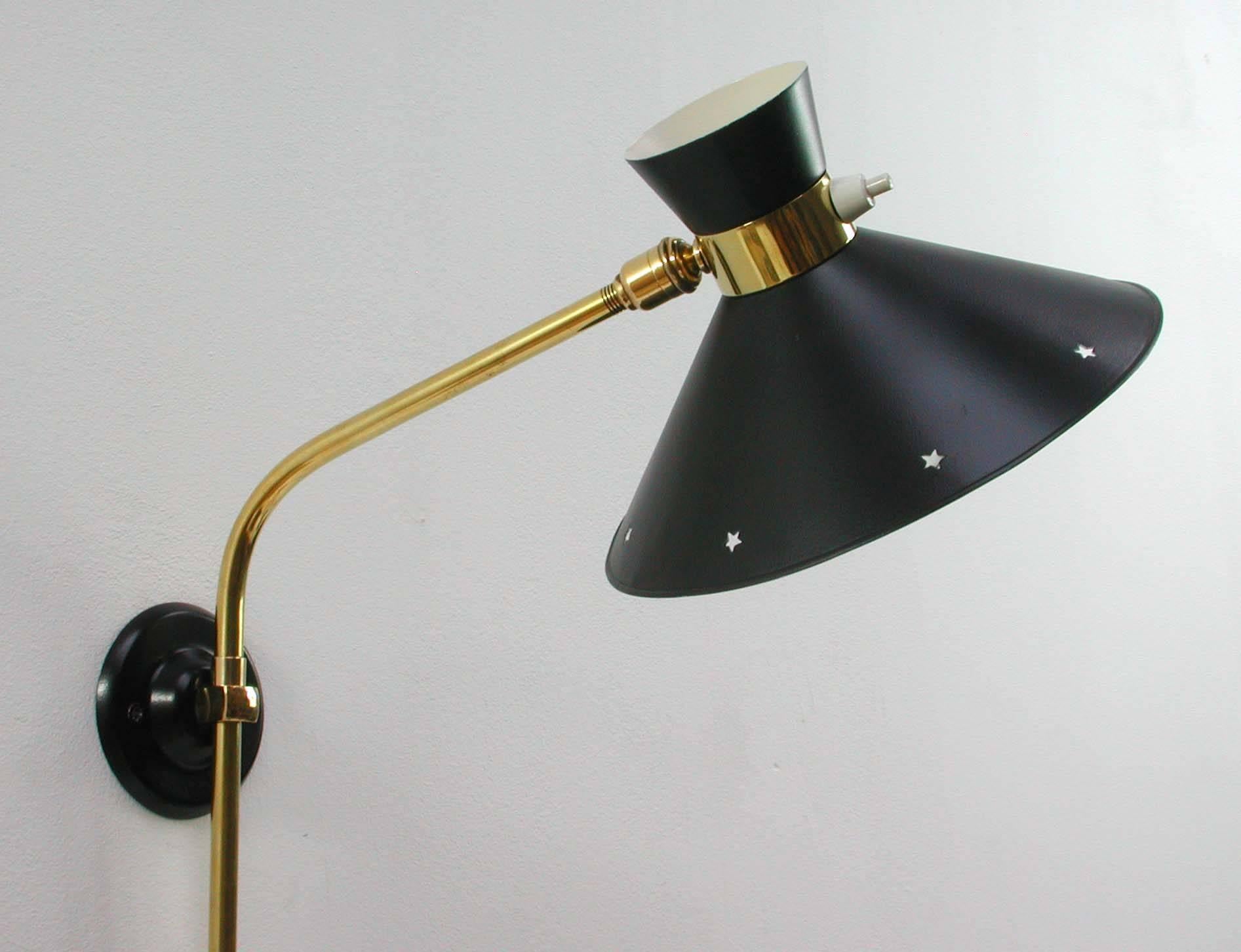 Original René Mathieu wall light or sconce by Maison Lunel. 

This wall light has got a black diabolo-shaped lampshade and brass swivelling lamp arm with brass details. It was produced in France in the 1950s.
 