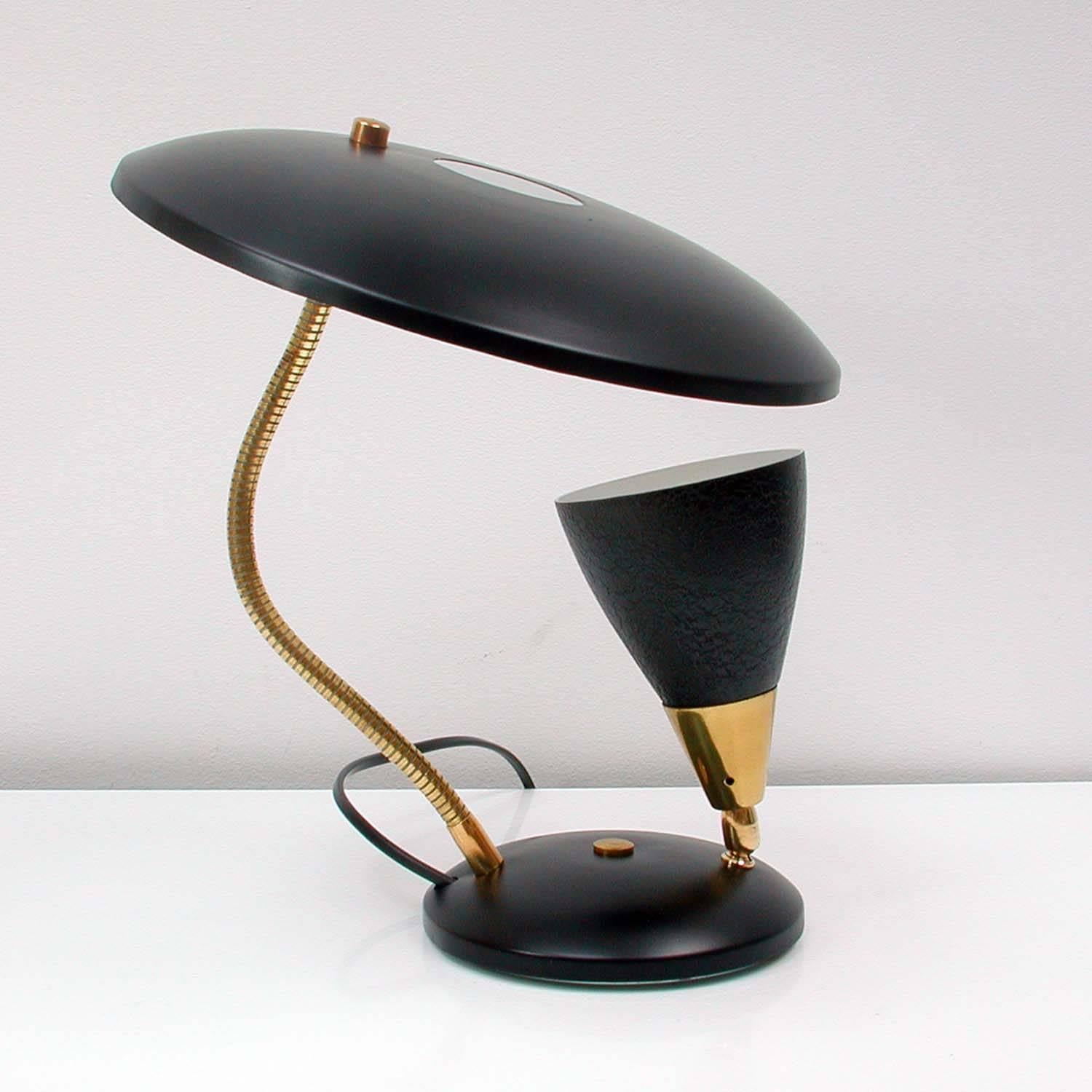 This Midcentury table light was designed and manufacrured in France in the 1950s.

It has got a black reflecting lampshade, a gooseneck lamp arm and an adjustable black and brass bulb holder.
The lamp is in excellent vintage condition and has been