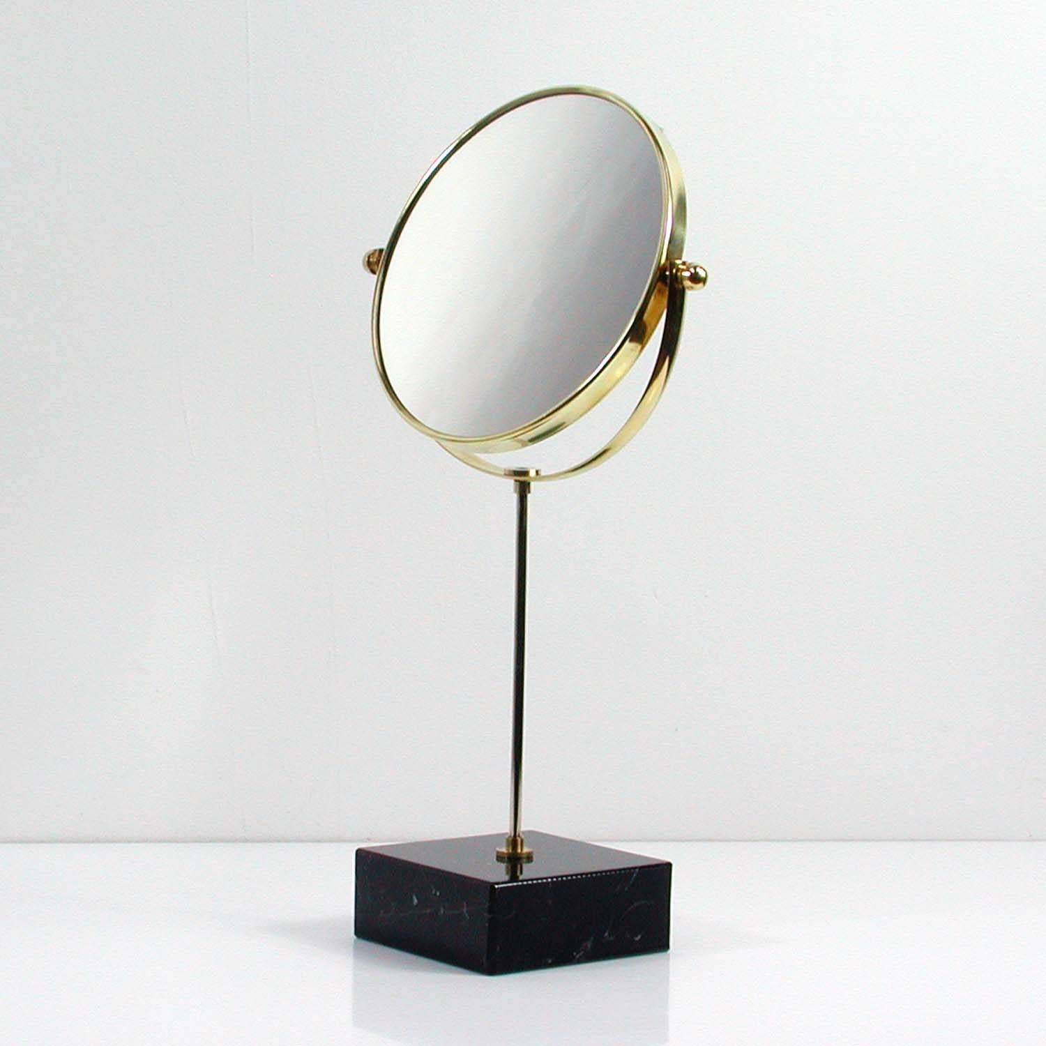 This elegant vanity mirror was manufactured in Italy in the 1950s.

The mirror has got an adjustable mirror top and a marble base. One side of the mirror has got normal mirror glass. The other side has got a magnifying mirror.
