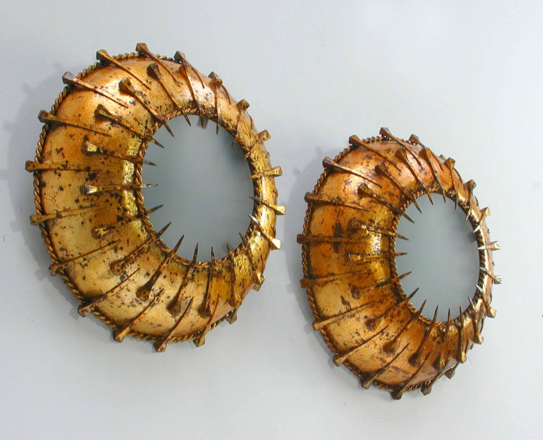 This pair of gilt metal and frosted glass sunburst sconces, wall lights or flush mounts were designed and manufactured in Spain in the 1950s. The lights have got two sockets each and have been re-electrified. Both lights with beautiful patina.

We
