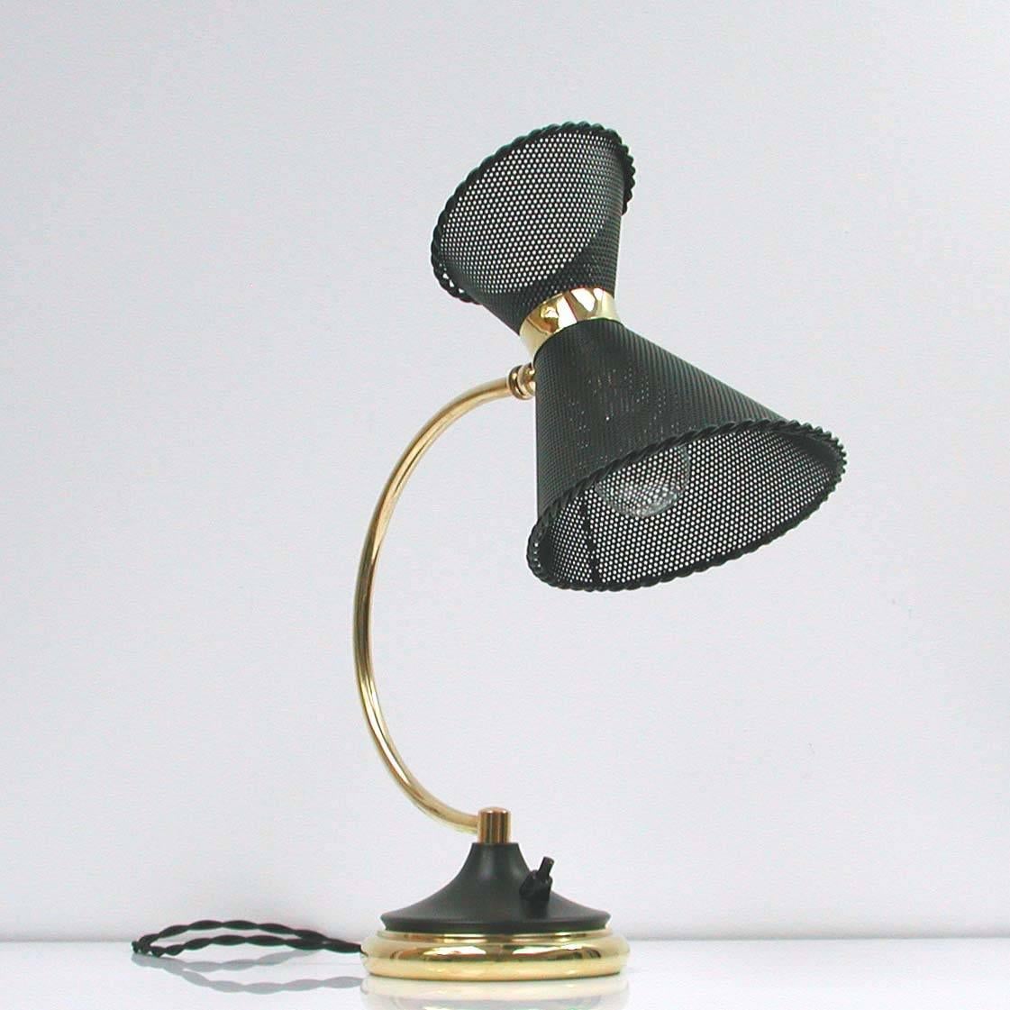 Very rare Mathieu Matégot attributed table lamp, made in France in the 1950s.

Brass lamp foot and rotatable black lacquered perforated lampshade.

The lamp has got a B22 bayonet socket and works on 110V as well as 220V.
European two-pin plug.