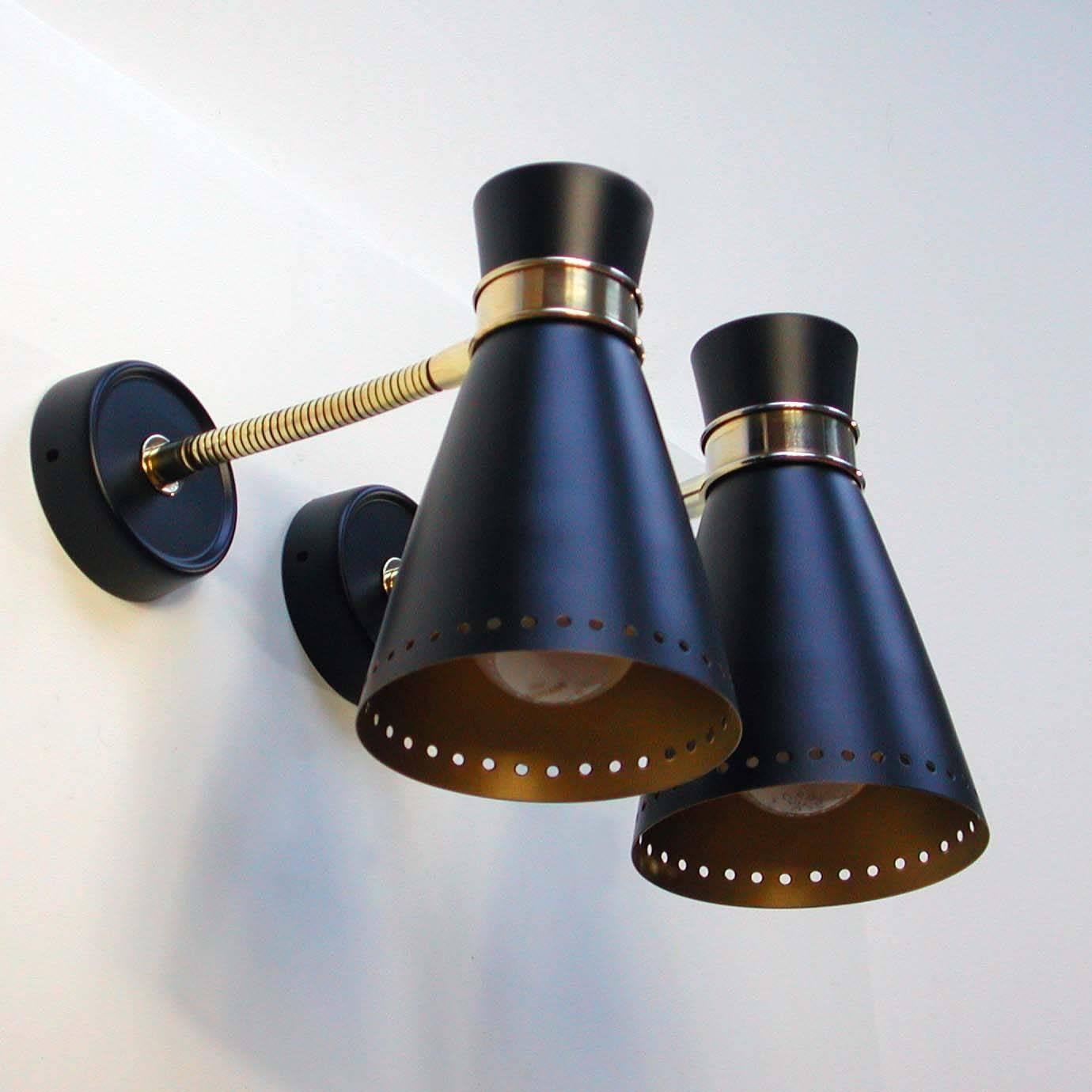 Set of two black and gilt lacquered sconces, made in Germany in the 1950s. Both lamp shades are adjustable and have been rewired for use in US.