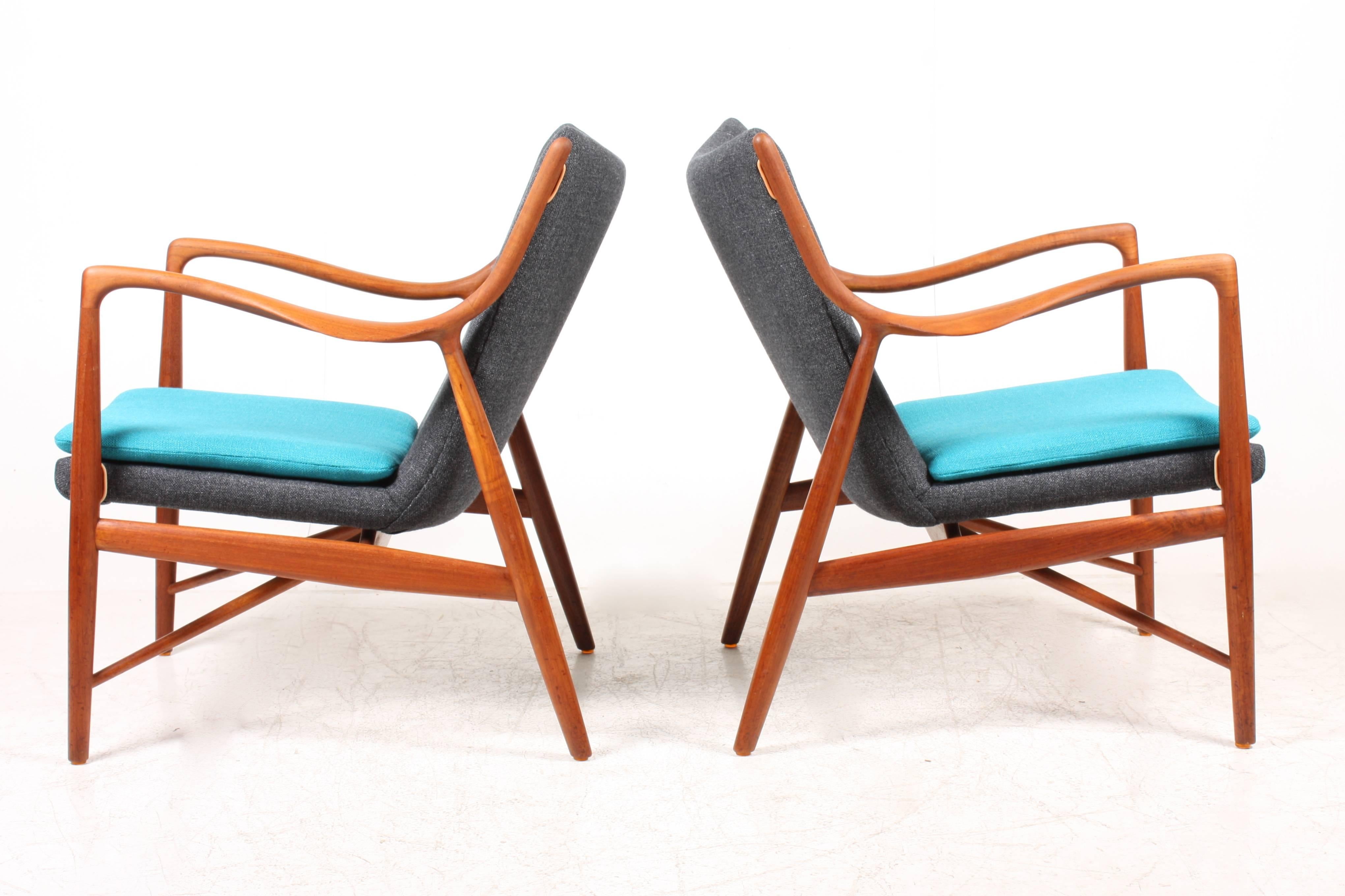 Pair of NV45 lounge chairs in teak with new fabric upholstery. Designed by Maa. Finn Juhl for Niels Vodder cabinetmakers in 1945. Made in Denmark.