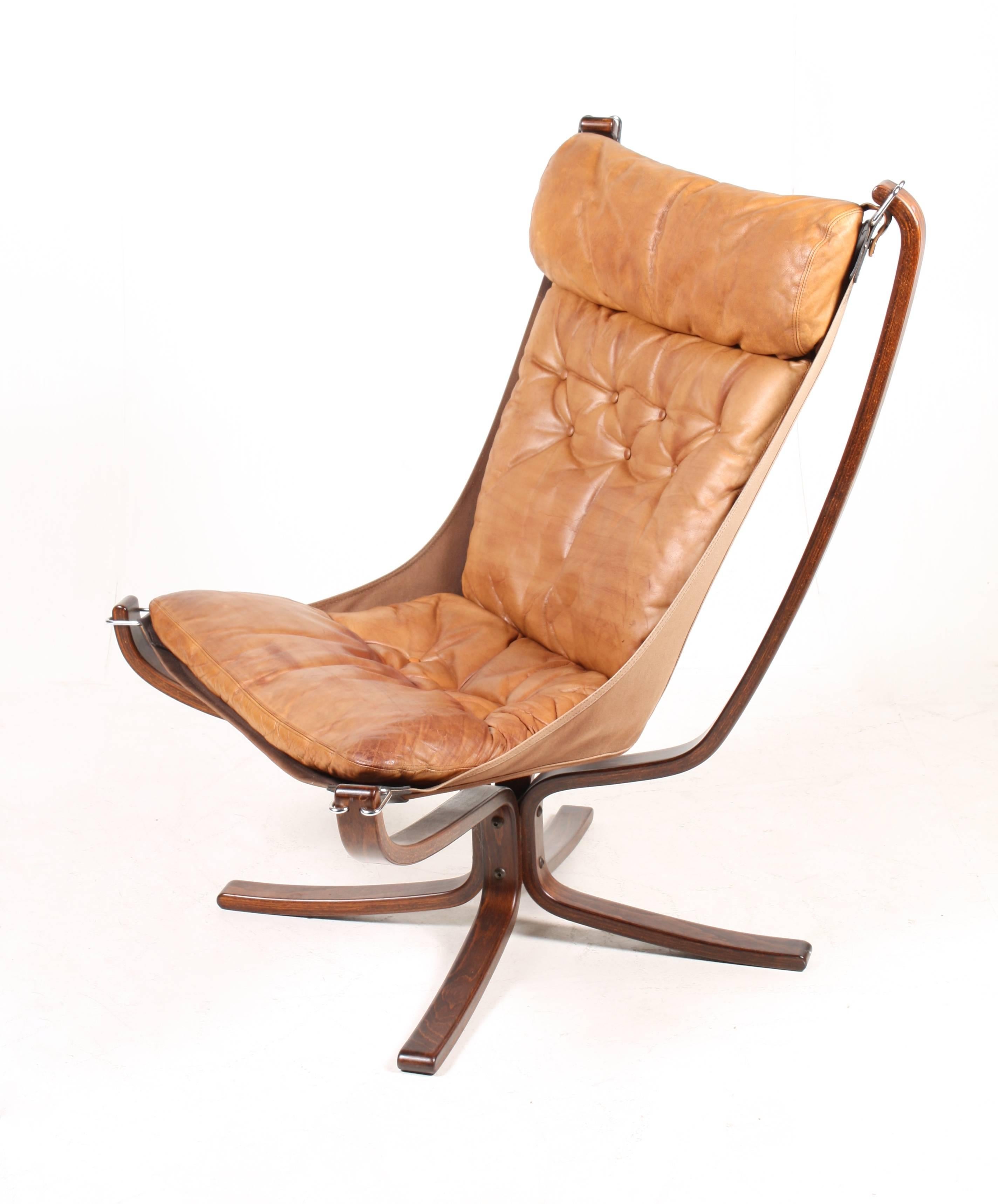 Pair of high back lounge chairs, stained beech frame and cushions in patinated leather. Designed by Sigurd Ressell for Vatne Furniture. Made in Norway. The chairs are in all original condition.