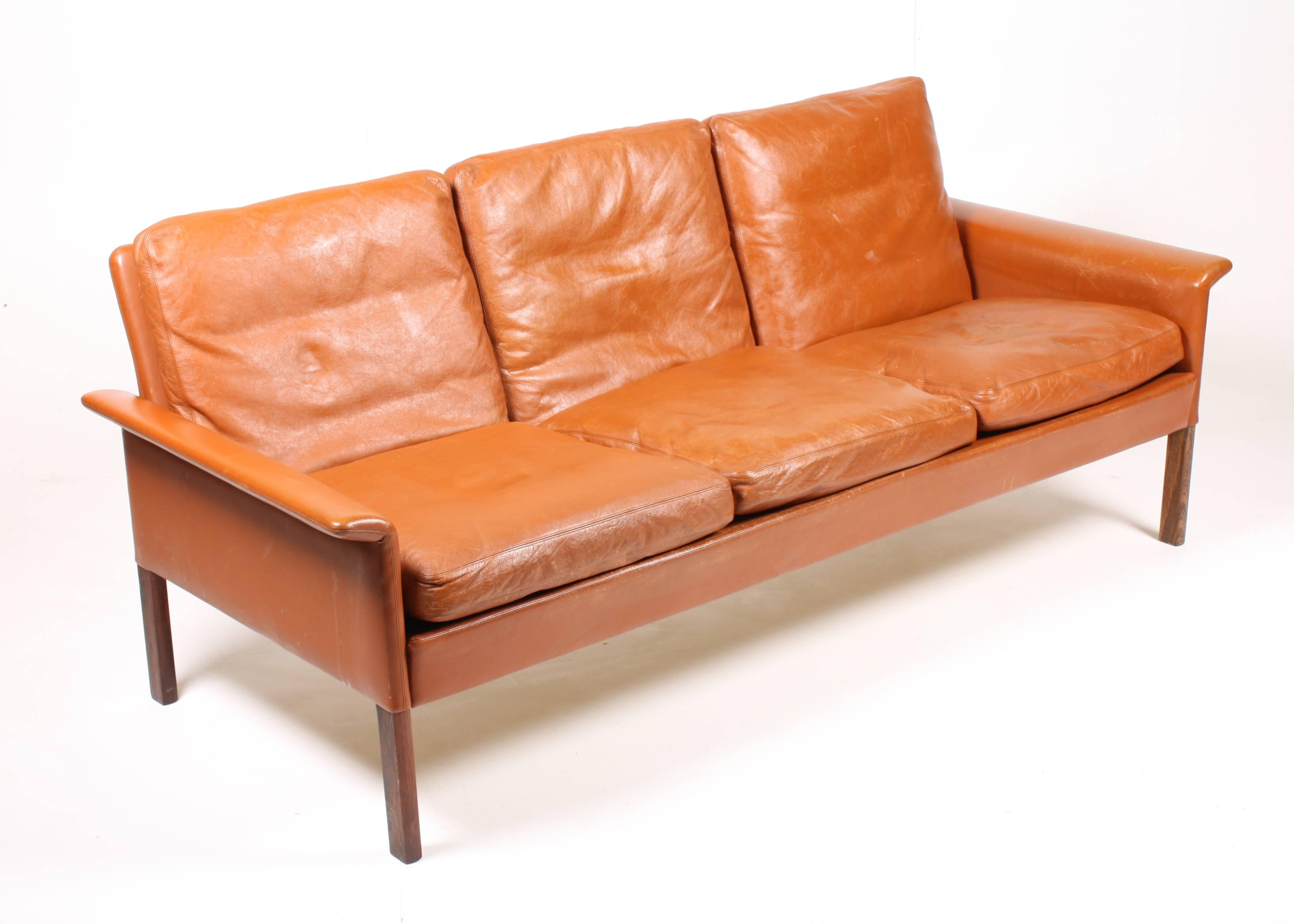 Great looking Danish design sofa in patinated brown leather and rosewood. Designed by Maa. Hans Olsen for CS Furniture in 1969. The sofa is cleaned, waxed and is from a non smoker home. Very nice original condition. Made in Denmark.