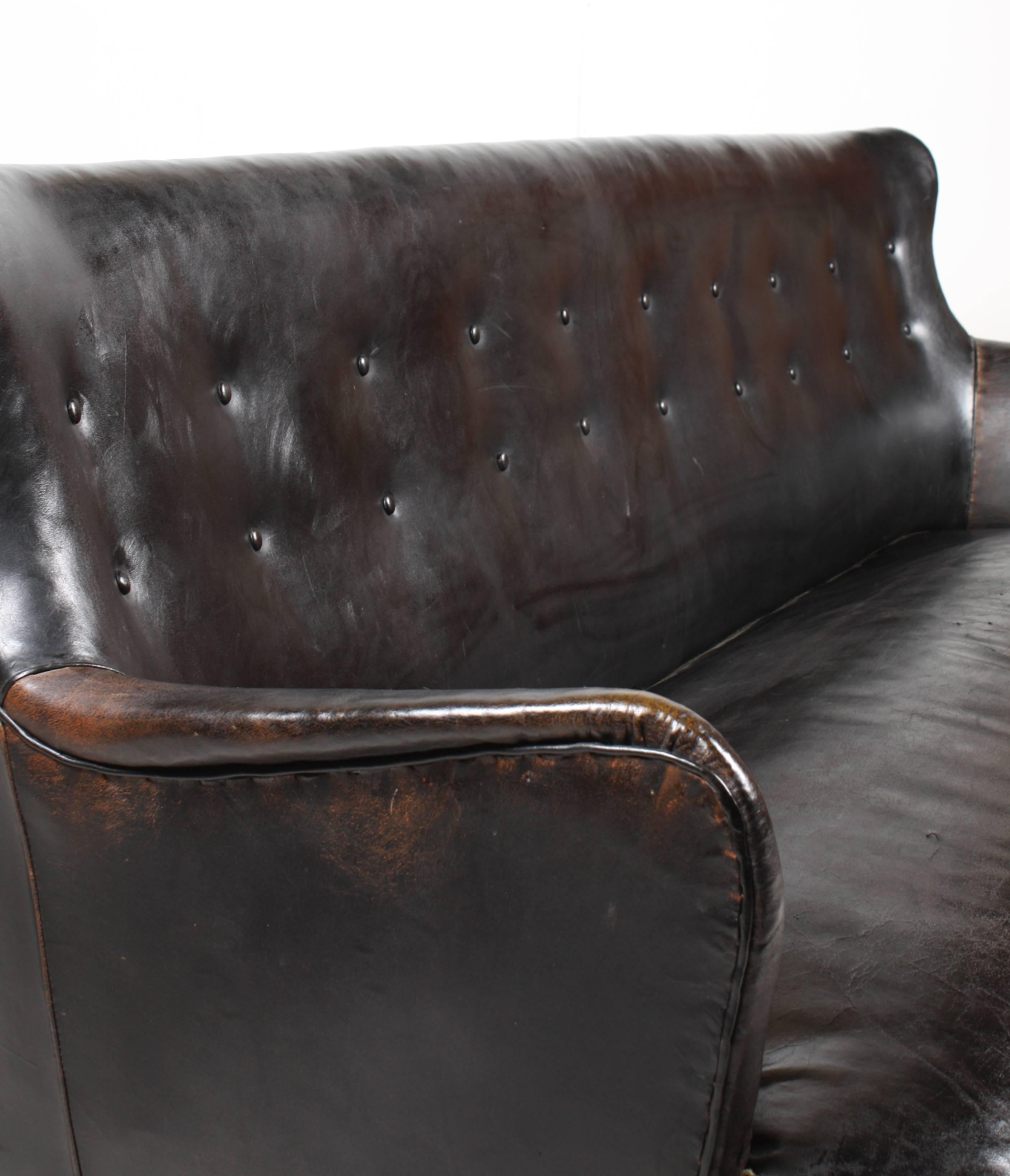 Three-seat sofa in patinated black leather designed by Maa. Peter Hvidt for Fritz Hansen cabinetmakers in the 1950s. Made in Denmark. Good original condition.