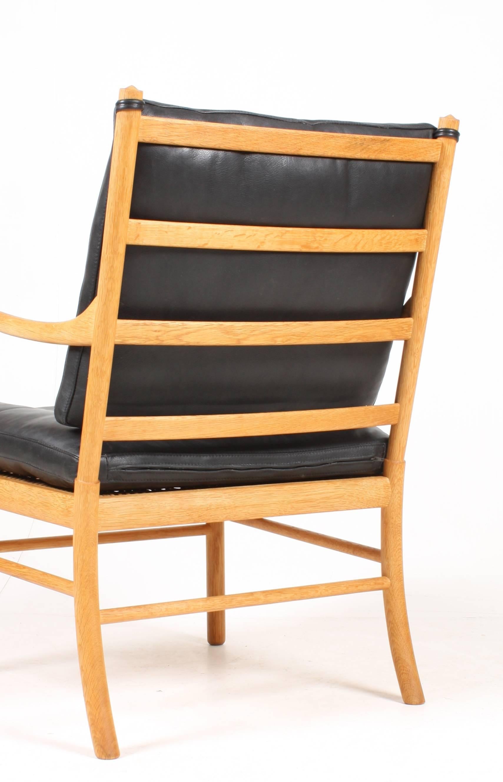 Pair of nicely patinated lounge chairs in oak and leather designed by Maa. Ole Wanscher in 1949. Made by Peter Jeppesen Cabinetmakers. Made in Denmark in the 1970s. The chairs are cleaned up and waxed, very nice condition.