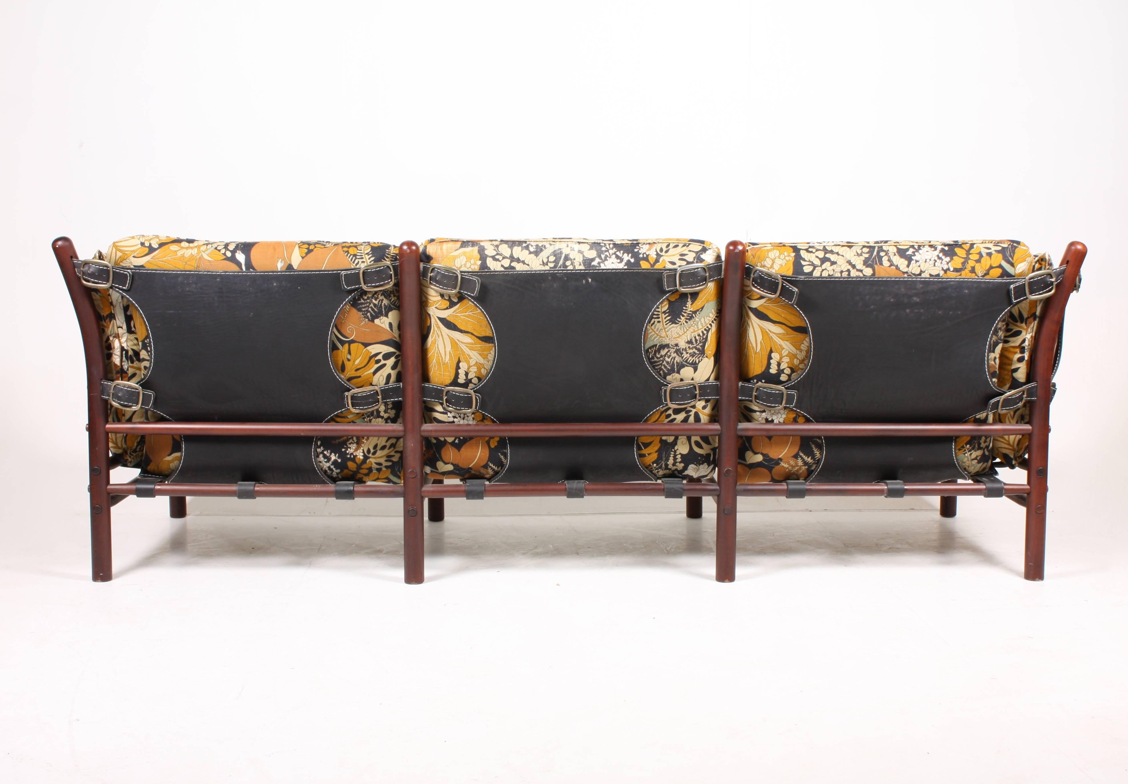 Three-seat sofa, model Ilona, designed by Arne Norell for Norell Møbel AB in the 1960s. This sofa has the rare floral print and support sides in leather. Made in Sweden. Great original condition.