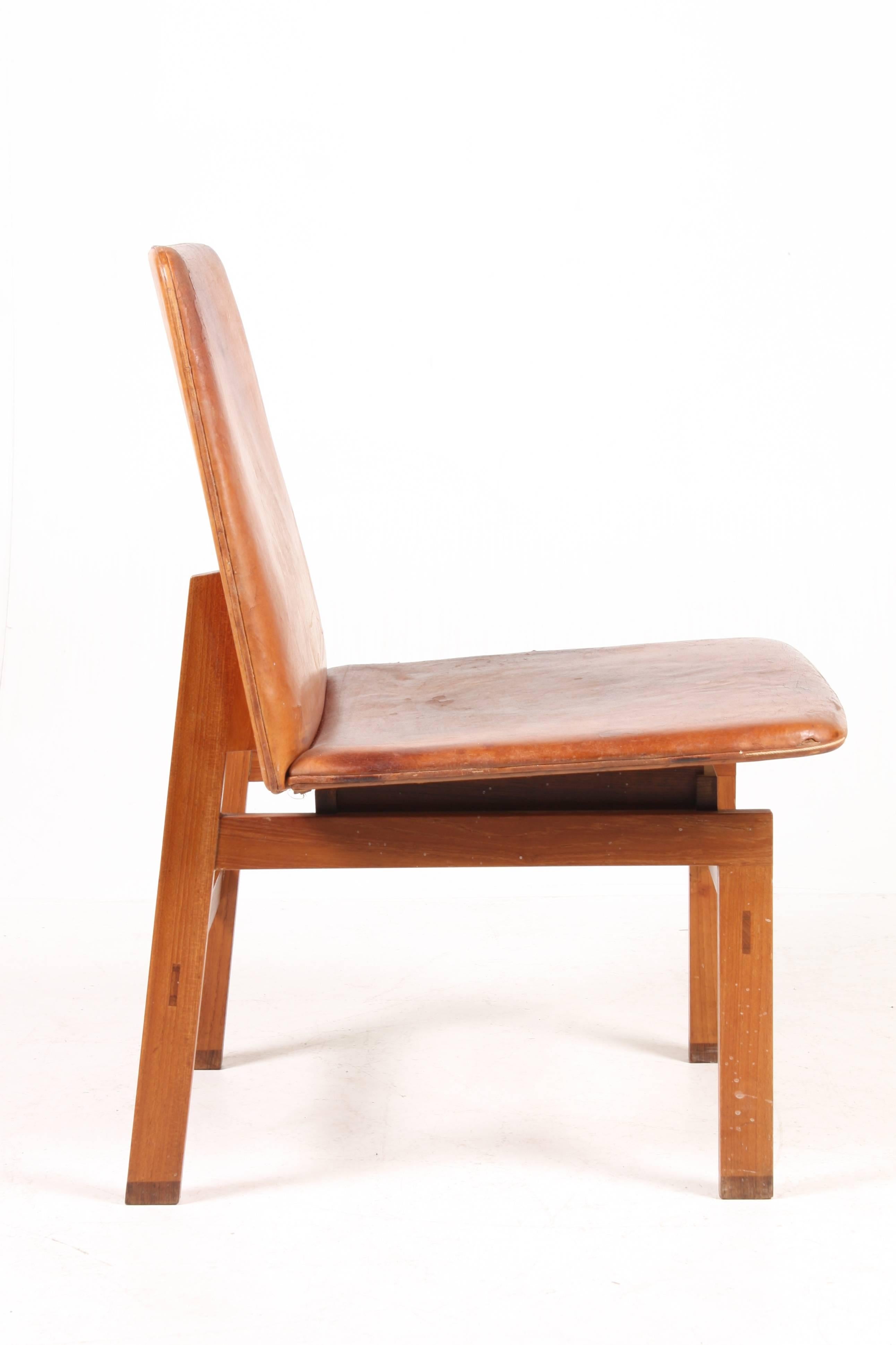 Stunning side chair in solid teak with rosewood details. Seat and back in patinated leather. Made in Denmark in the 1950s.