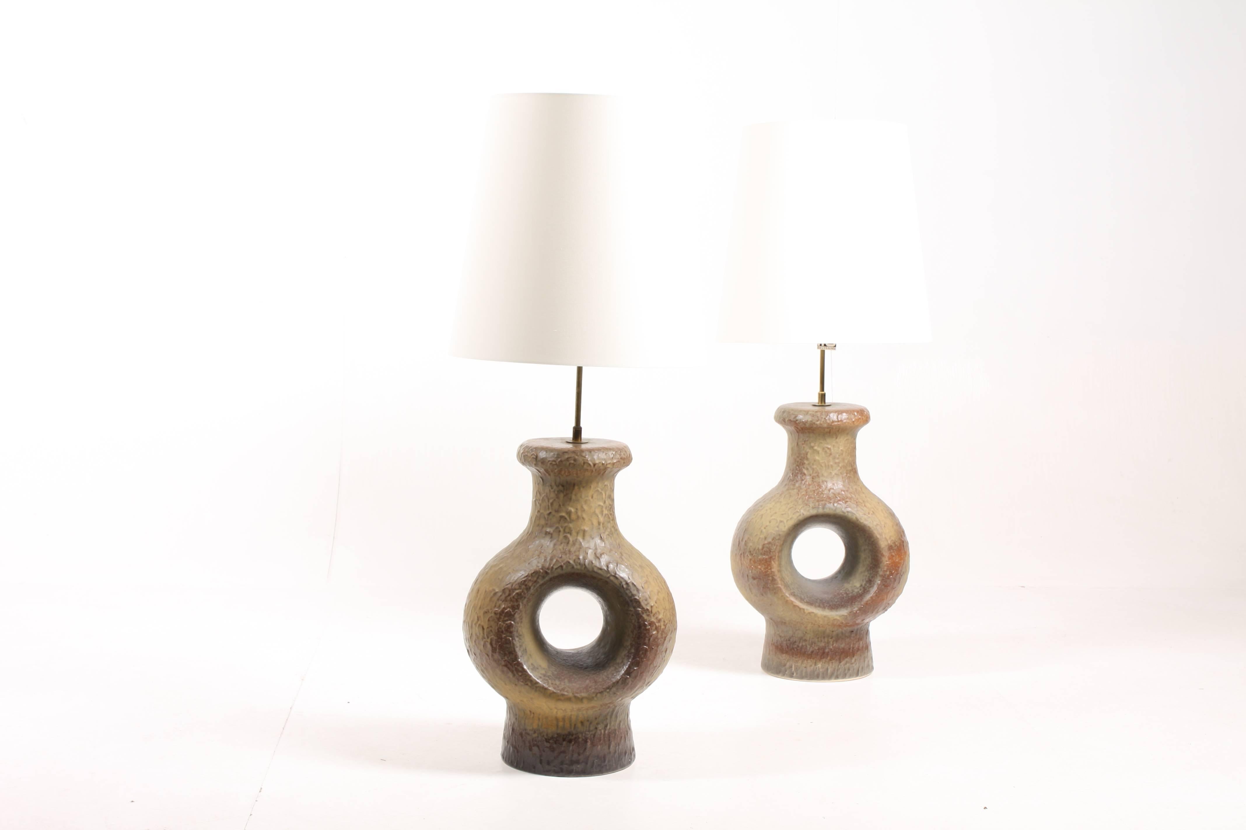 Pair of artefact table lamps handmade and designed in Denmark in late 1960s. Very minimalistic brass detailing combined with the ceramic Stand.
Comes with new lampshades.