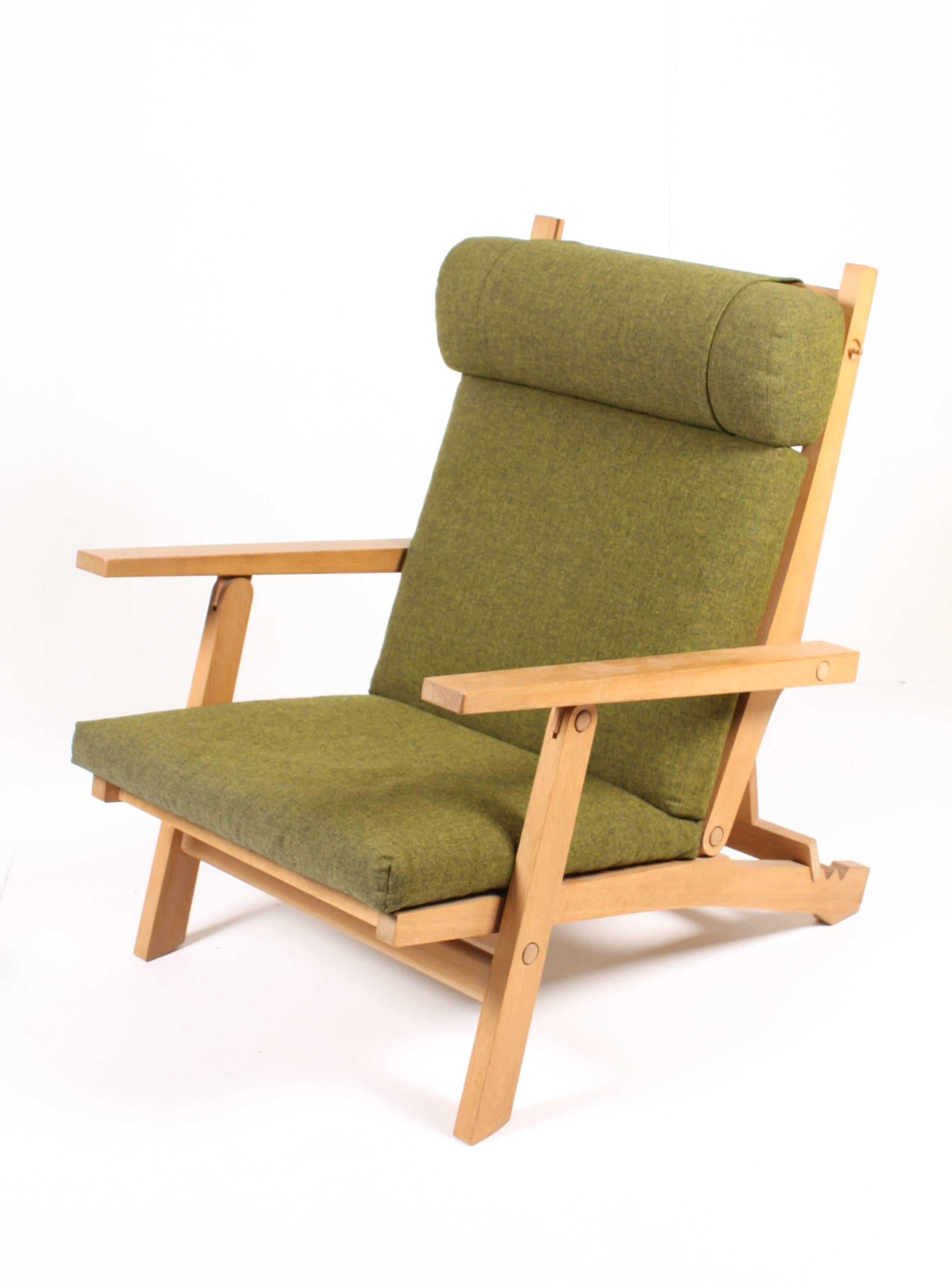 Pair of AP71 folding lounge chairs in solid oak with green wool upholstery. Designed by Hans J Wegner for AP stolen Valby in the 1968. Great original condition. A rare folding oak frame lounge chair with an adjustable back and headrest. The design