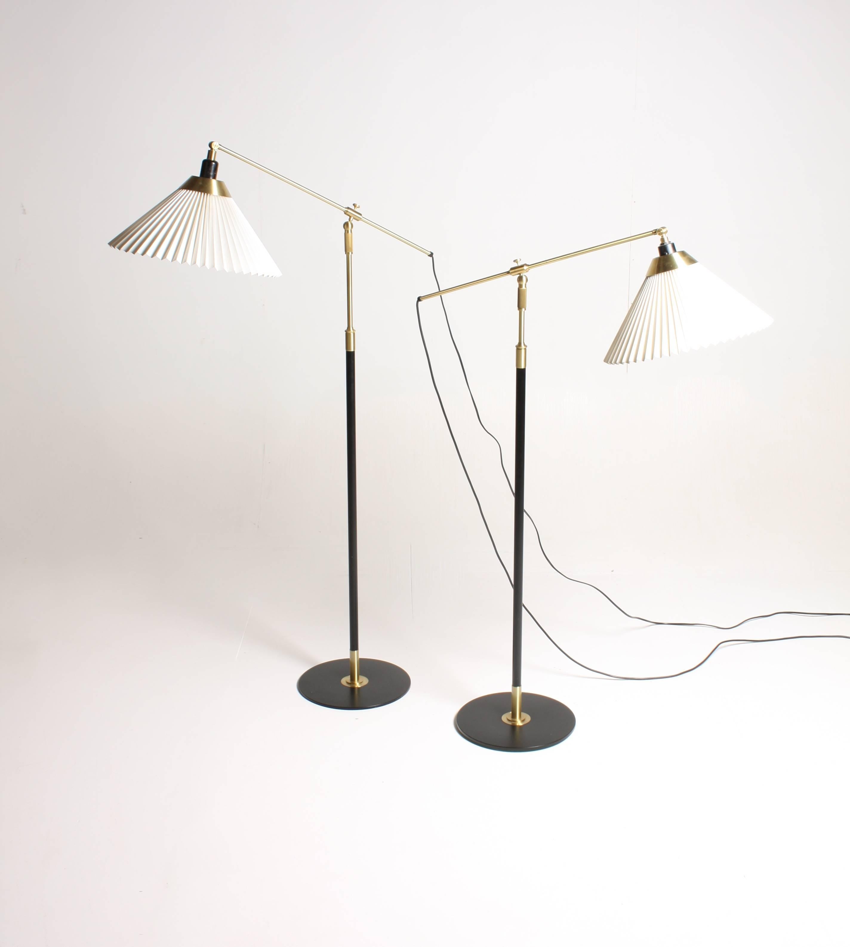Pair of adjustable floor lamps in black painted metal and brass designed by Le Klint studio. Made in Denmark. Very nice original condition.