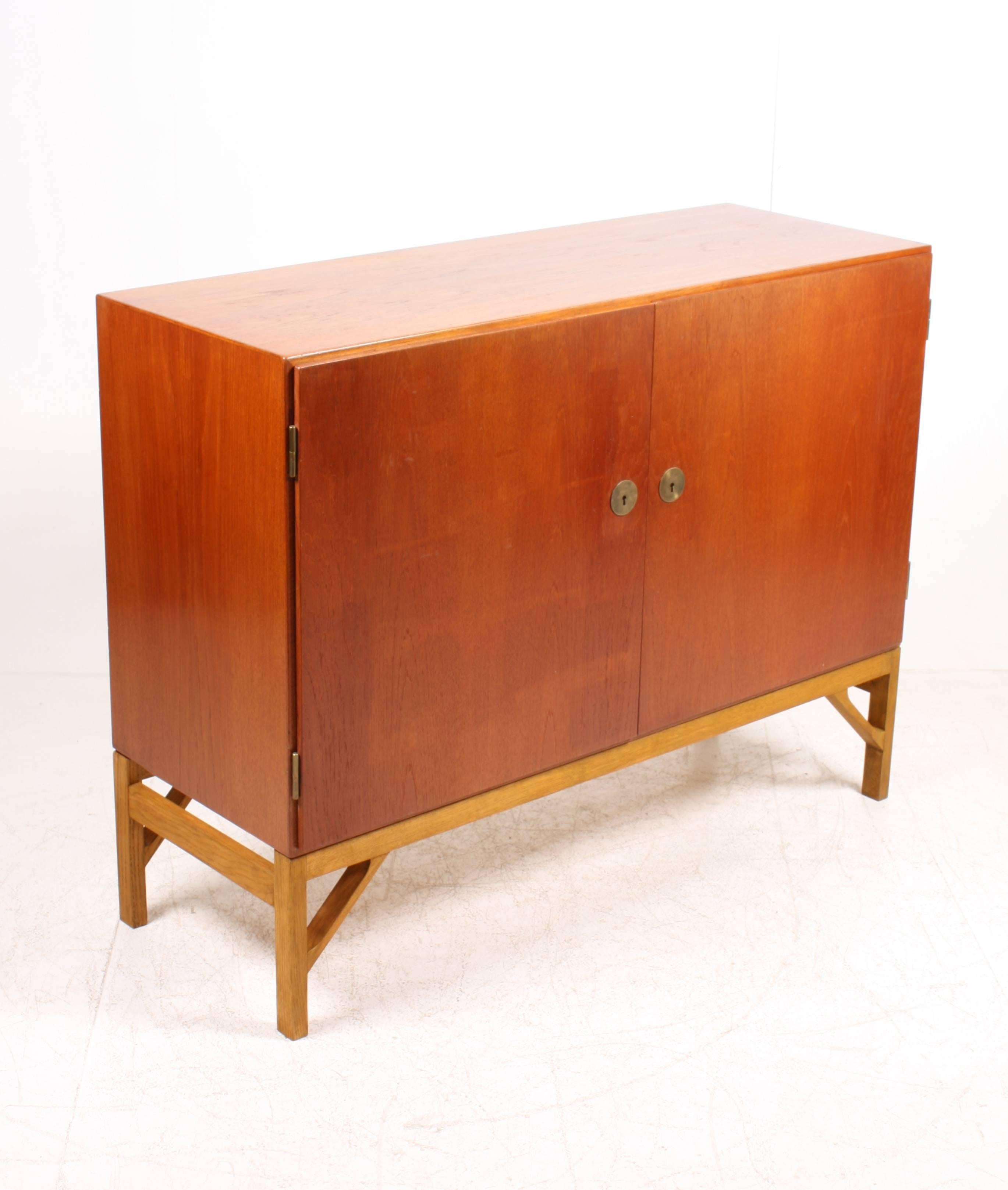 China cabinet in teak on an oak base with stunning hardware in brass and maple Interior. Designed by MAA. Børge Mogensen in the 1950s and this piece is made by CM Madsen cabinetmakers Denmark in the 1960s. Great original condition.