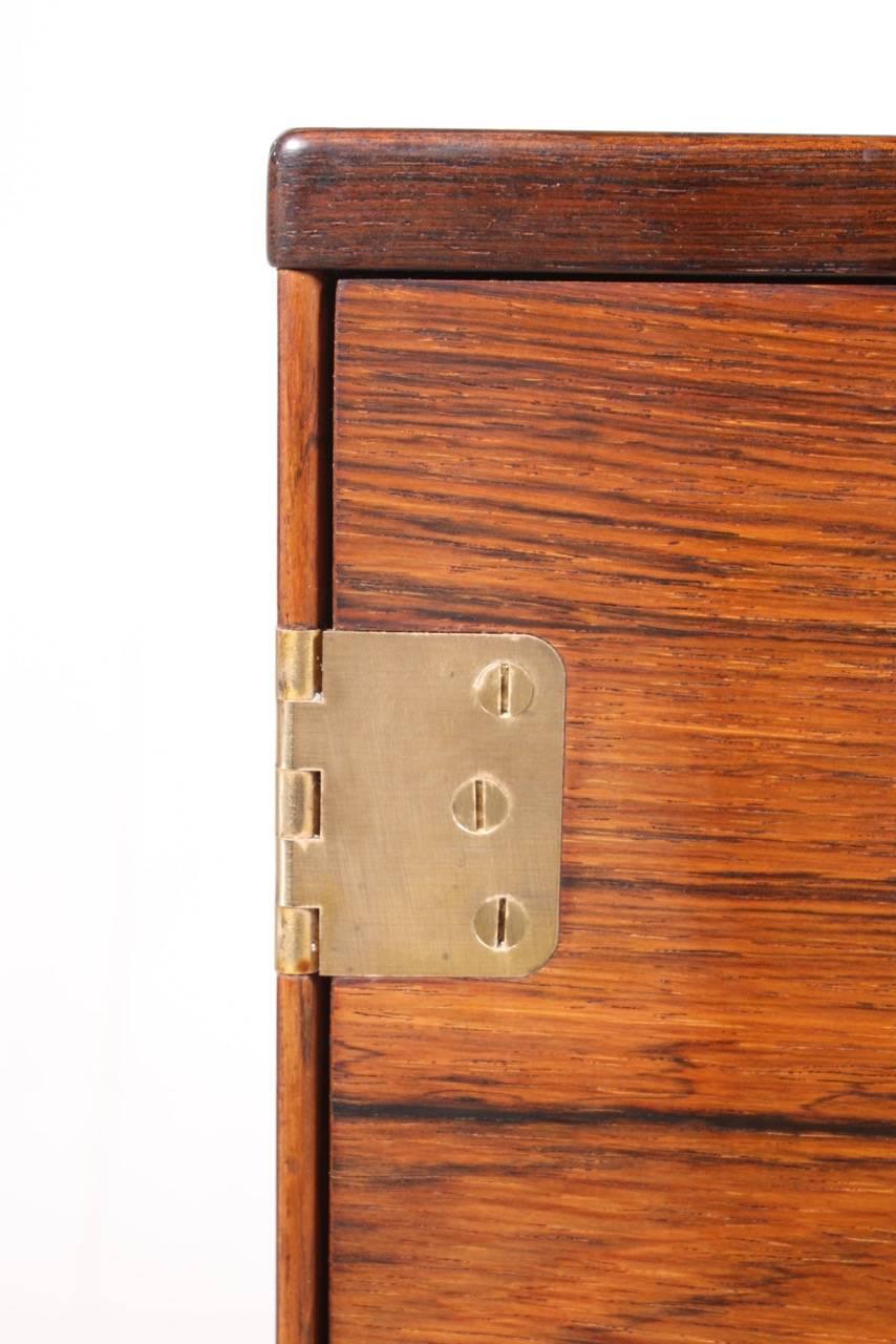 Cabinet in rosewood with brass hardware. Designed by Svend Langkilde, Denmark in the 1960s. Great original condition.