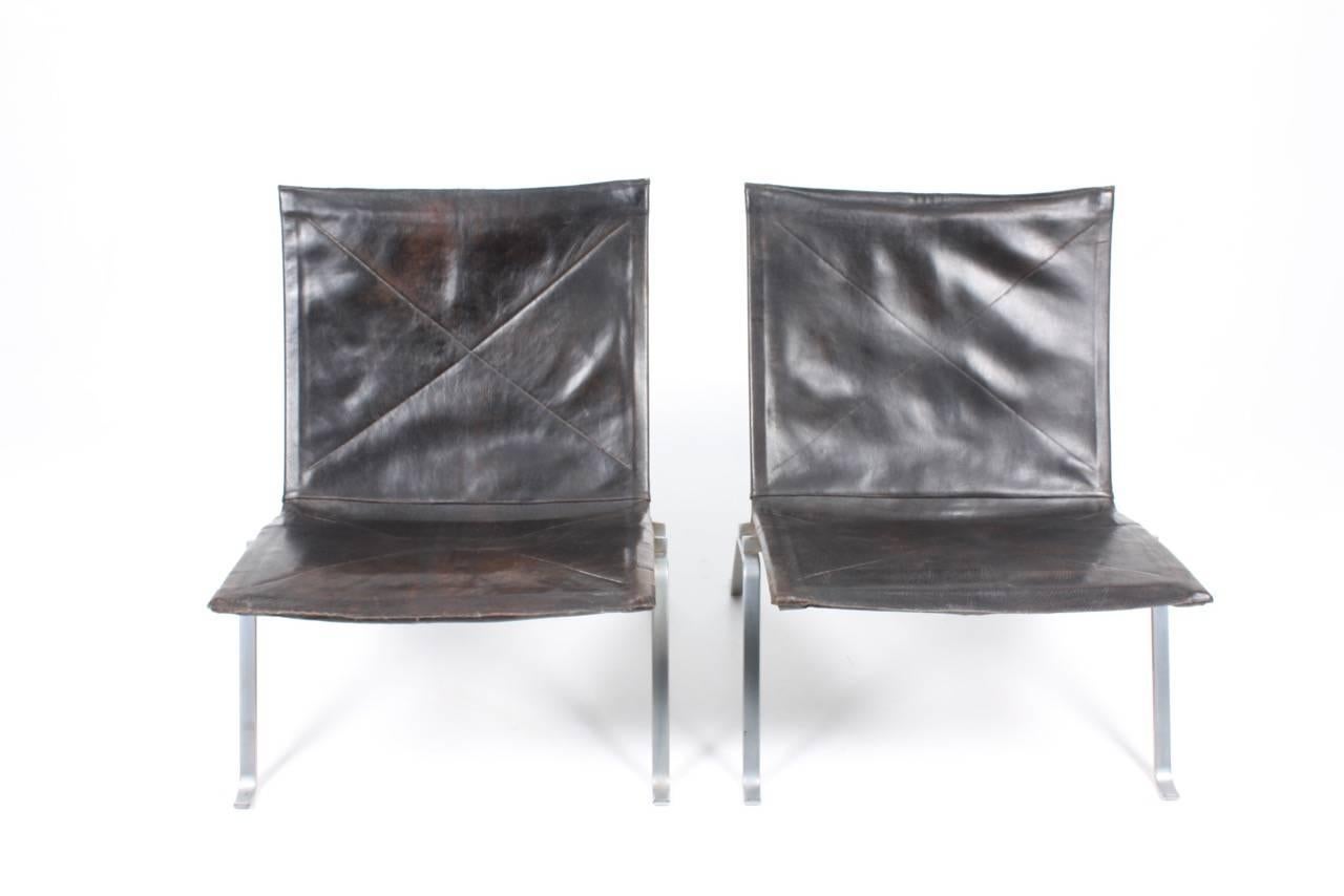 Pair of PK 22 lounge chairs in patinated leather, out standing patina. Designed by Poul Kjærholm and made by E. Kold Christensen Denmark in the 1960s, original condition.