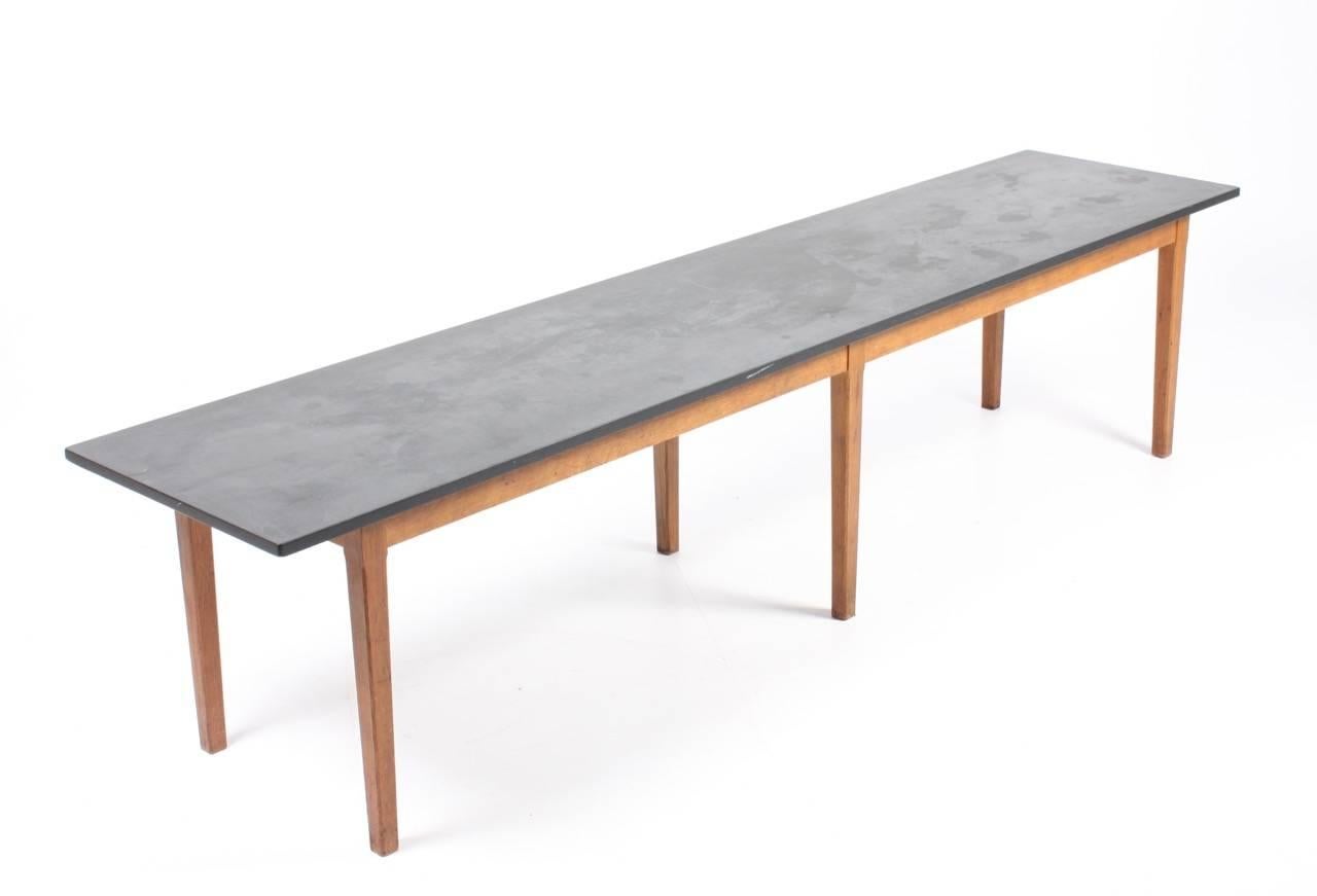 Long rectangular coffee table with a patinated slate top on a solid oak base. Frame with a Made in Denmark in 1960s. Great original condition.