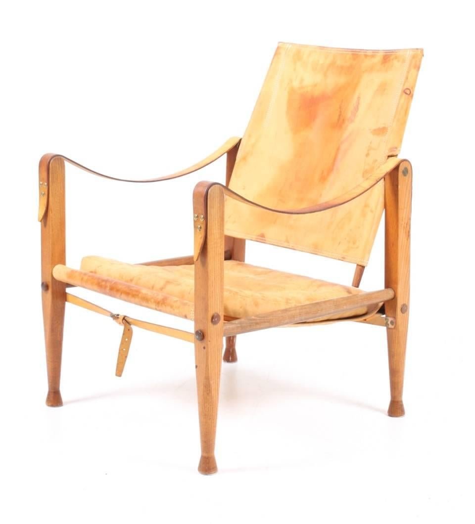 Safari chair in elm and well patinated natural leather designed by Maa. Kaare Klint for Rud Rasmussen cabinetmakers in 1933. This chair is from the 1960s. Made in Denmark. Great original condition.