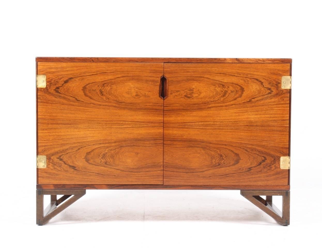 Elegant cabinet in rosewood with brass hardware. Designed by Svend Langkilde M.A.A. Made in Denmark, circa 1965. Great original condition.