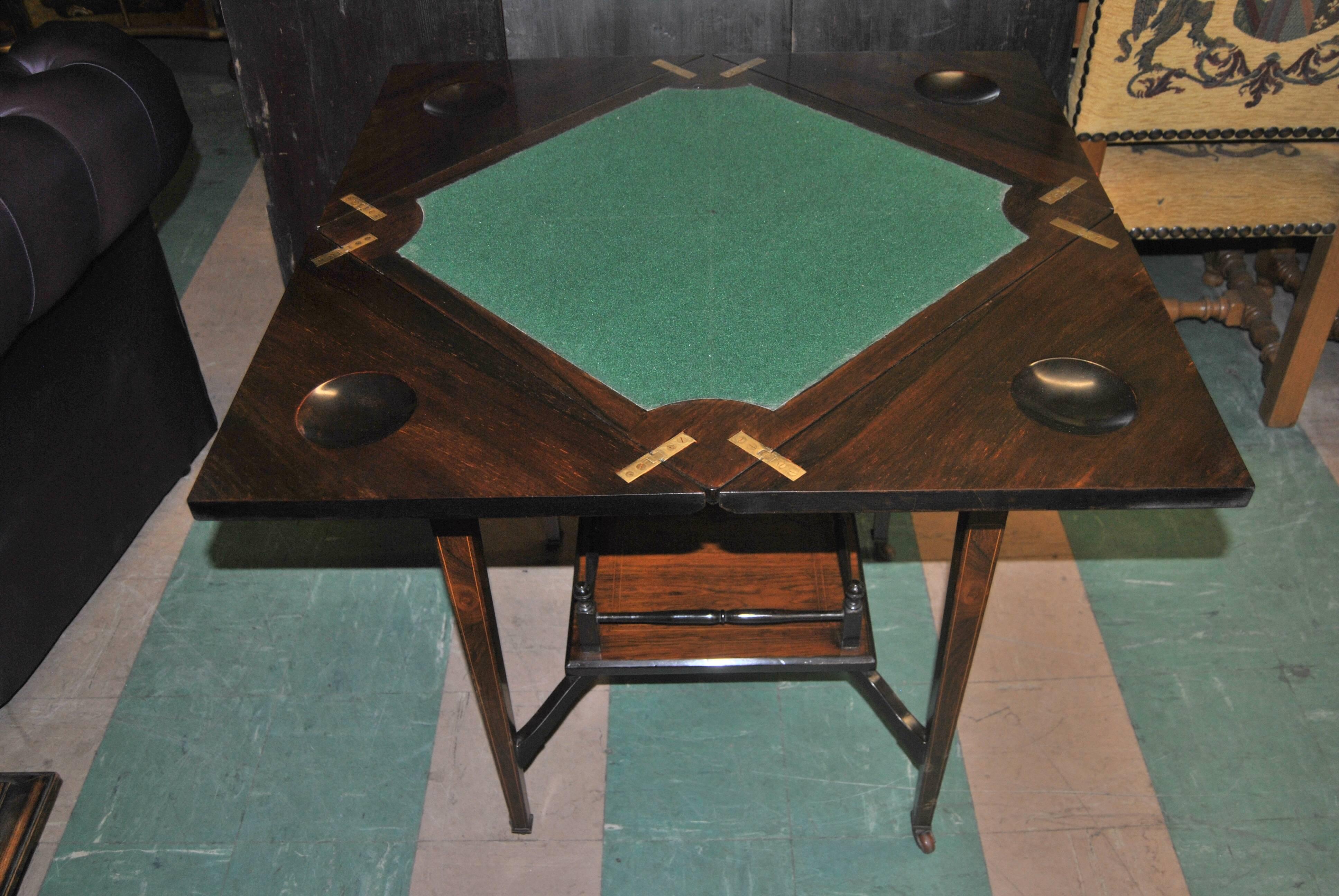 This is an envelope or game table made in England, circa 1900. It is made of the finest rosewood. Each quarter of the top and the drawer front is highly inlaid with the most beautiful, fabulous quality inlay imaginable. The top swivels so that each
