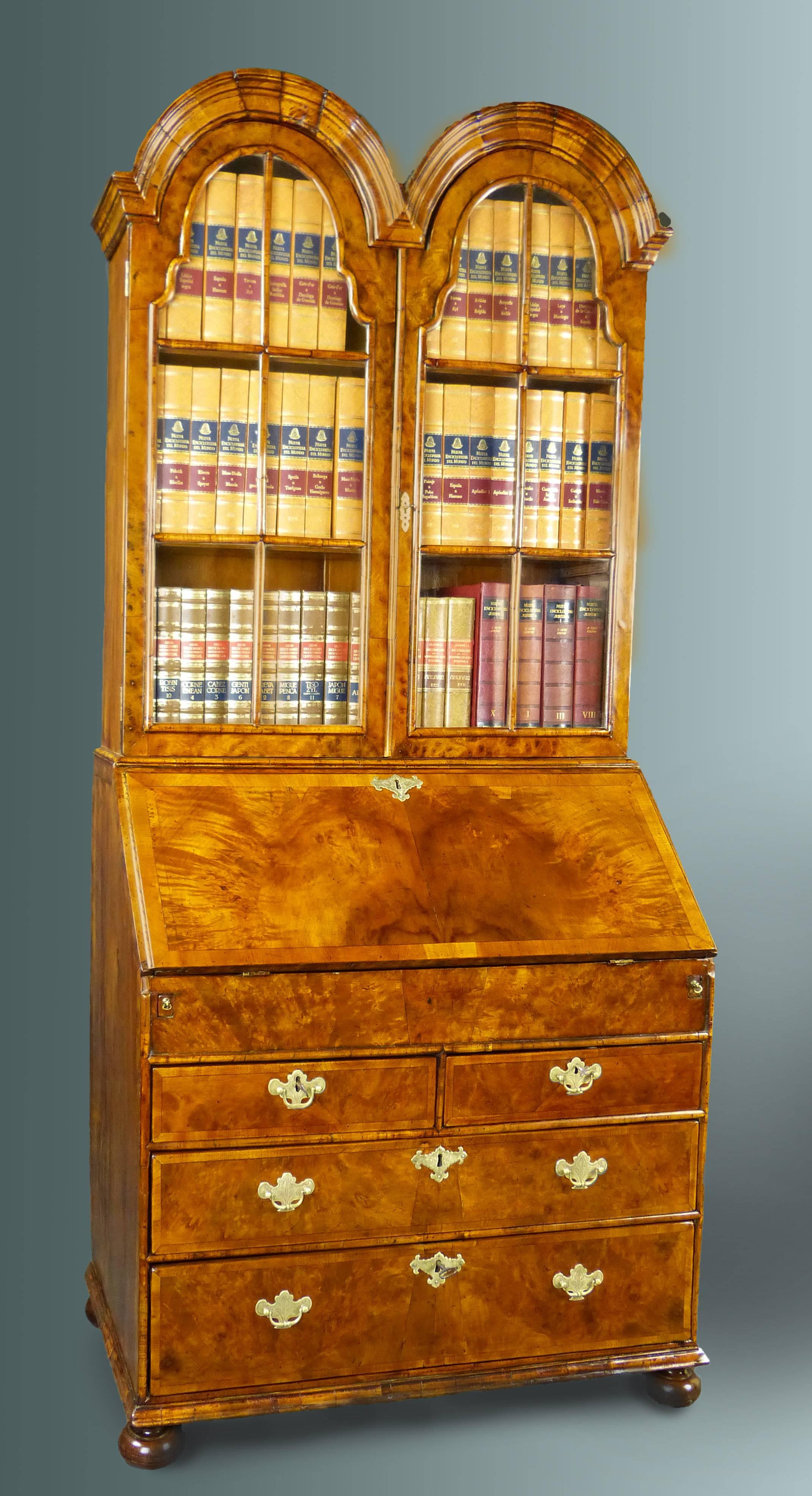 Queen Anne burl walnut bureau bookcase secretaire from early 18th century with moulded double domed bookcase top. The bureau part with slanting fall front and interior writing surface of original inset leather, featuring various open compartments in