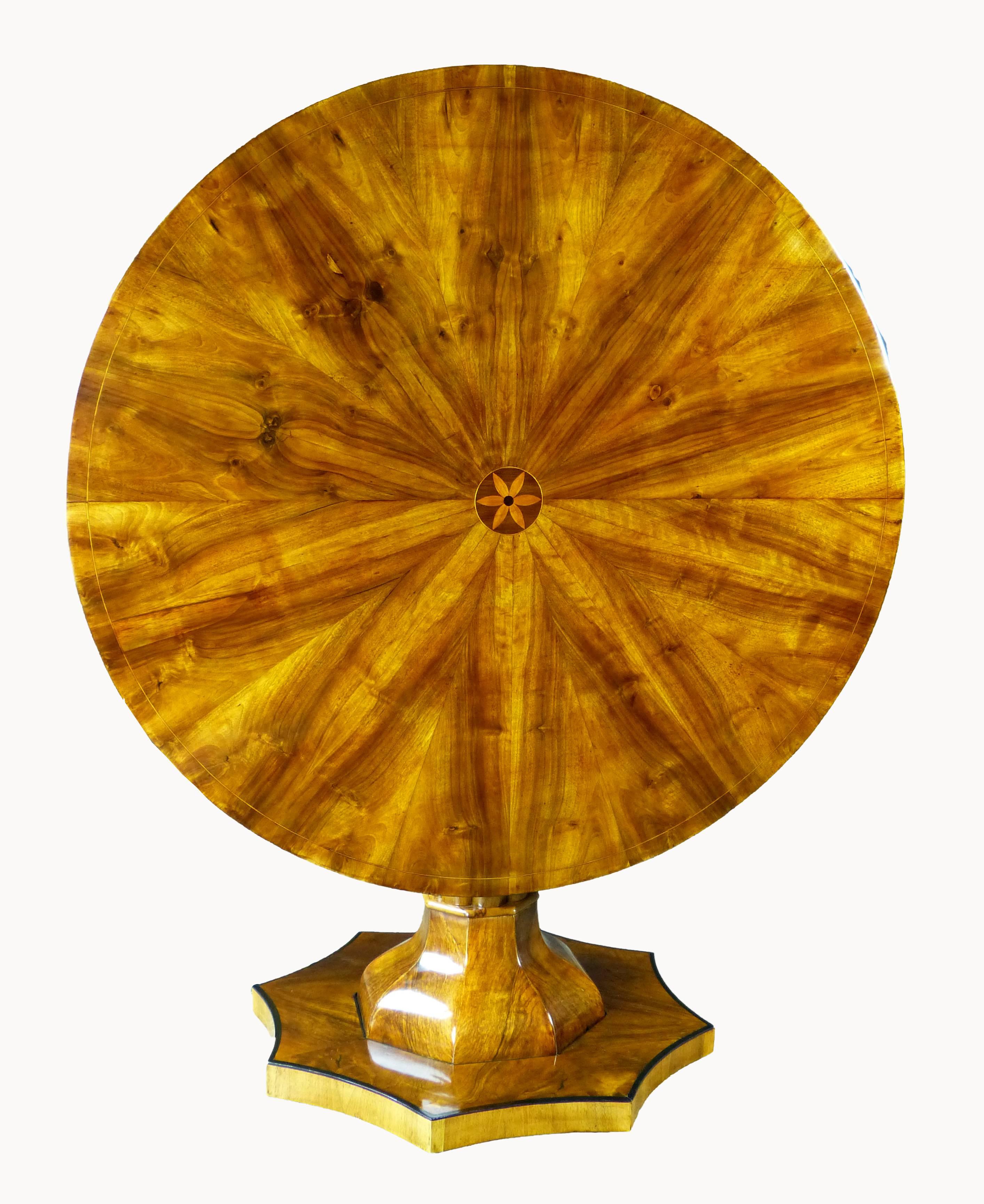 Fine and rare Biedermeier circular center table, the top inlaid with 10 times! repeating sunburst pattern of finely figured walnut with a flower center and line inlay. Its unique base of various complex forms of unequalled mastery with a cluster of