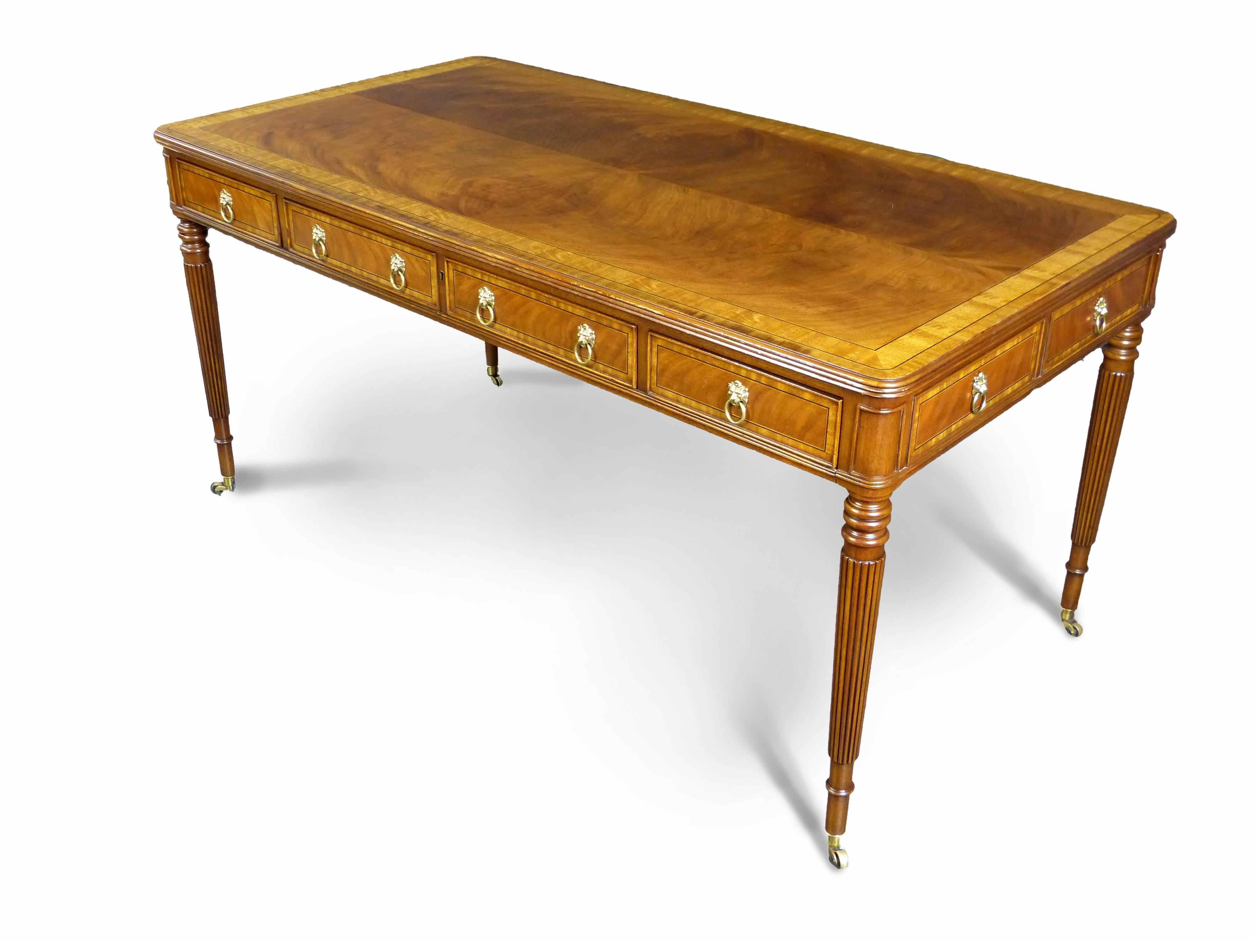 A fine quality mahogany and satinwood writing desk in the Regency style by E.J. Victor the rectangular top with rounded corners and satinwood banding with ebony line inlay. There are three freeze drawers on one side, the central one being of double