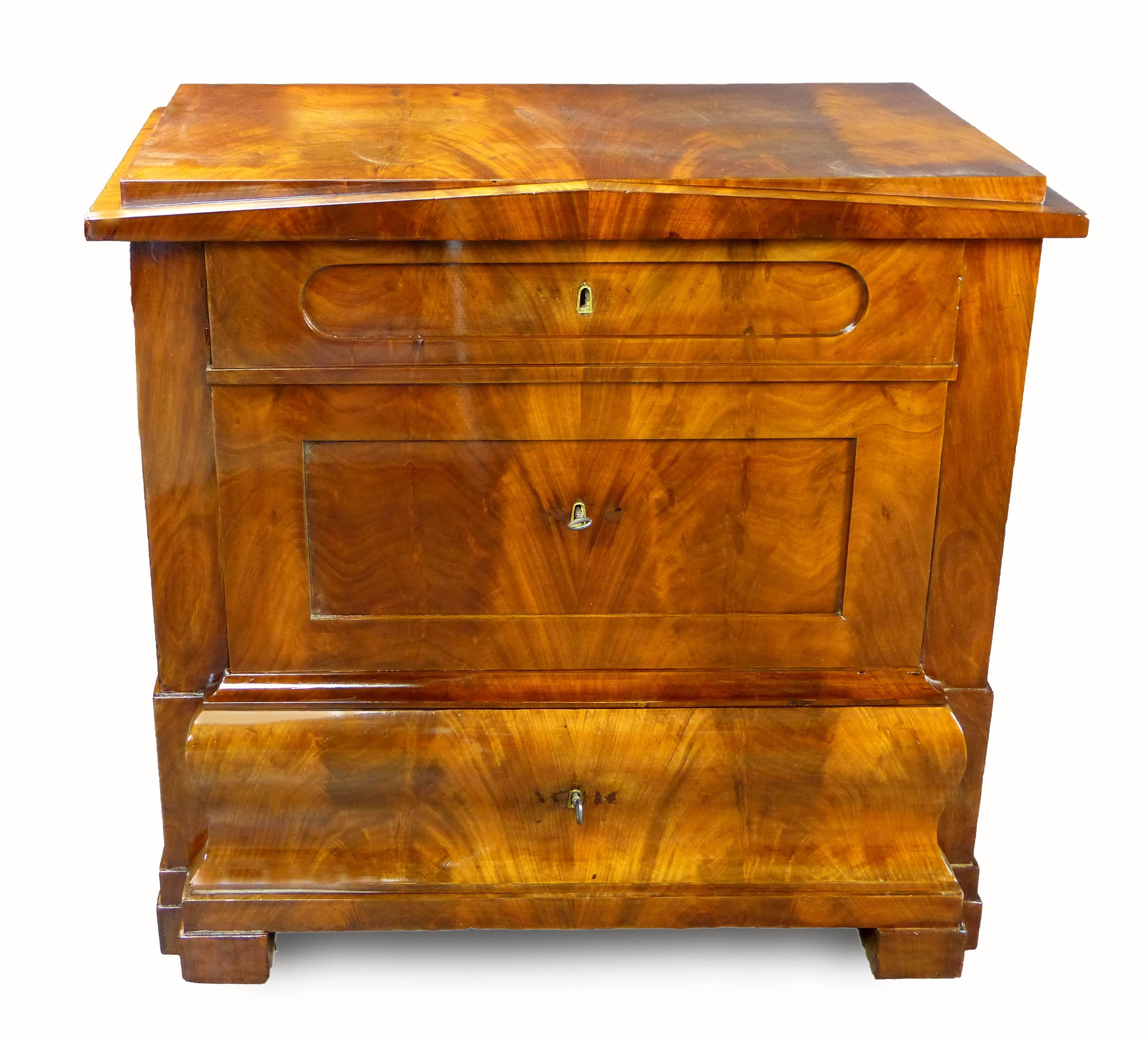 Fine Biedermeier period commode of architectural form with Schinkel pediment (after the famous Prussian architect). Three drawers of different size and form all with original locks and keys. The middle drawer deep enough to accommodate sheets or