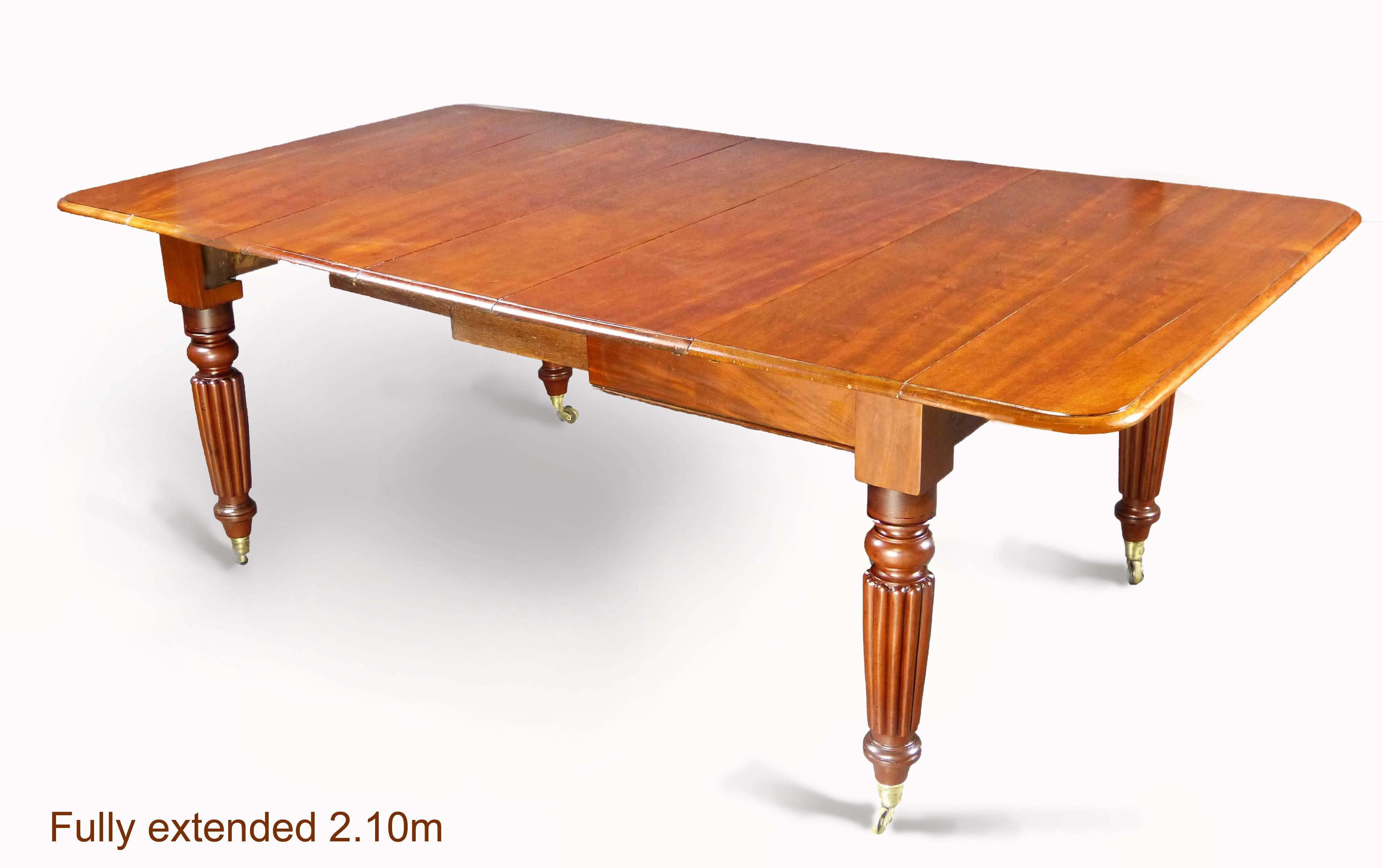 Mid-19th century solid mahogany English drop-leaf table extends to 210 cms with three extension leaves, of very robust construction with 4 beautifully turned and gadrooned tapering legs in the Gillows manner terminating in brass cup and wheel