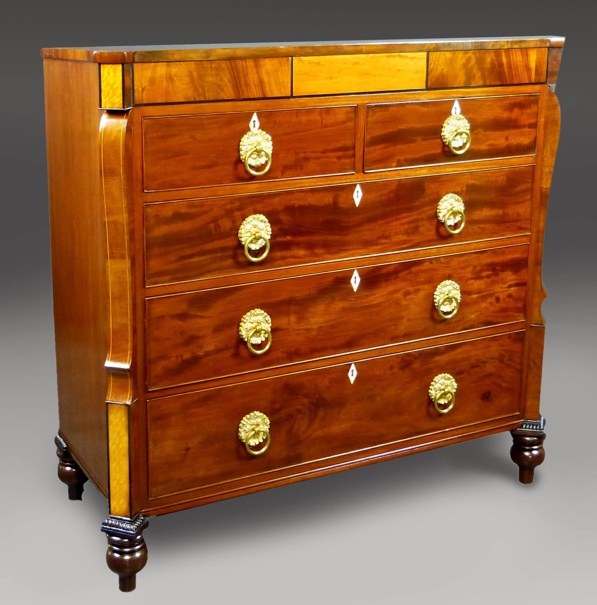 Fine and unusual mahogany chest of drawers dating to the William IV period of England (1830-1838) with rare angled and moulded pillars decorated with satinwood panels with ebony trim and moulded line inlaid walnut. The straight front features a