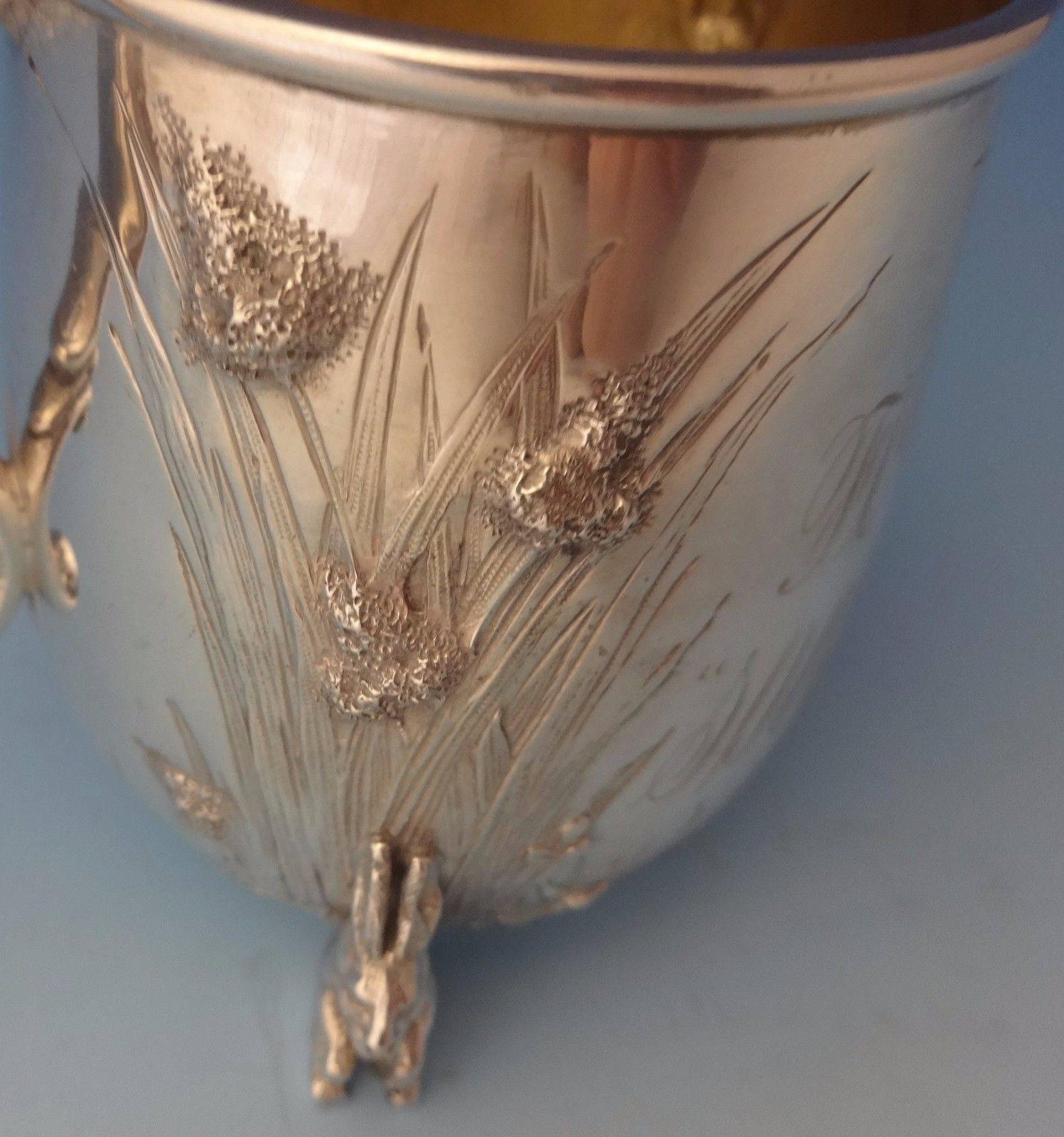 This fine sterling Easter Bunny baby cup was made by Tiffany & Co. featuring 3-D rabbits as the feet. It is repoussed and chased with grasses and foliage. There is also a bright cut spider web. It has a gold washed interior. The piece is monogrammed