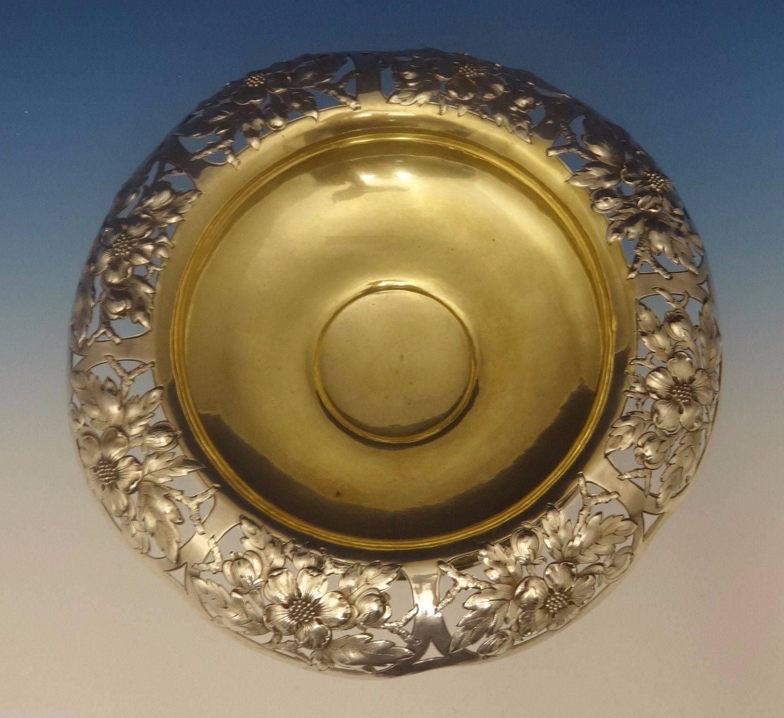Gorham.

This marvelous sterling silver centerpiece bowl was made by Gorham. It features a wide floral pierced border and a gold washed interior. The base is also pierced and chased with flowers. The piece is marked with #8041 and it dates from