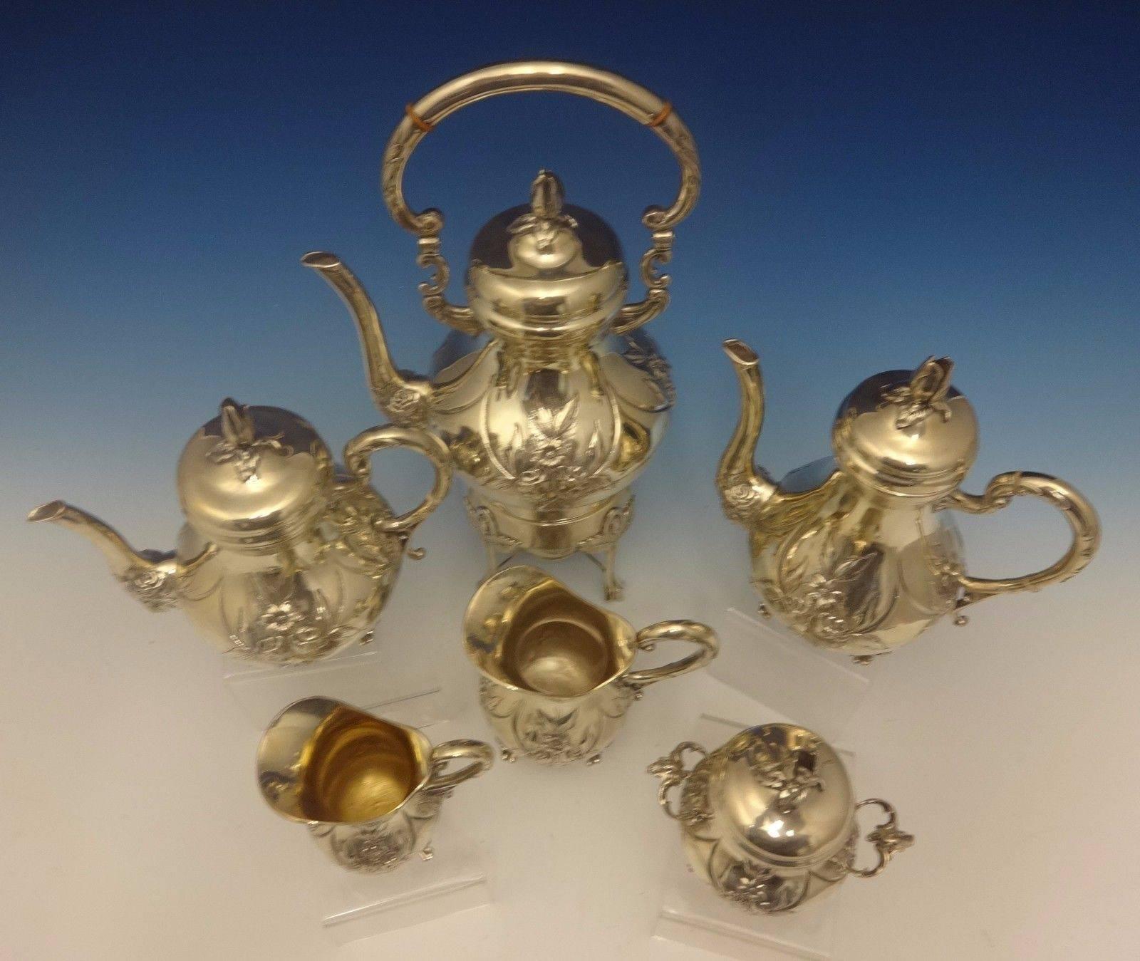 German silver.

Sterling silver six-piece tea set marked Handarbeit which means handmade in German. It features hand chased and applied flowers, including rose blossom finials. The set includes:

Coffee pot: Measures 9