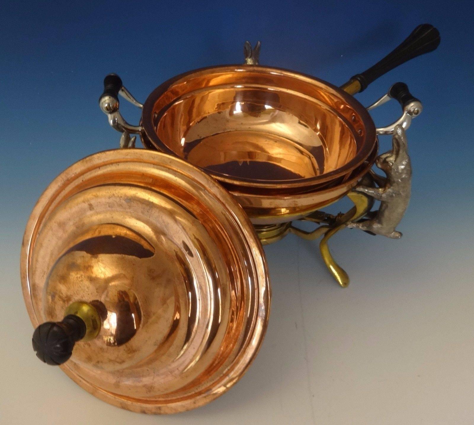 Joseph Heinrichs.

 This copper and brass chafing dish was made by Joseph Heinrichs. The piece has silverplate 3-D rabbits with a copper and bronze pot and ebony finials and handle. It dates from about 1905 and it measures 12