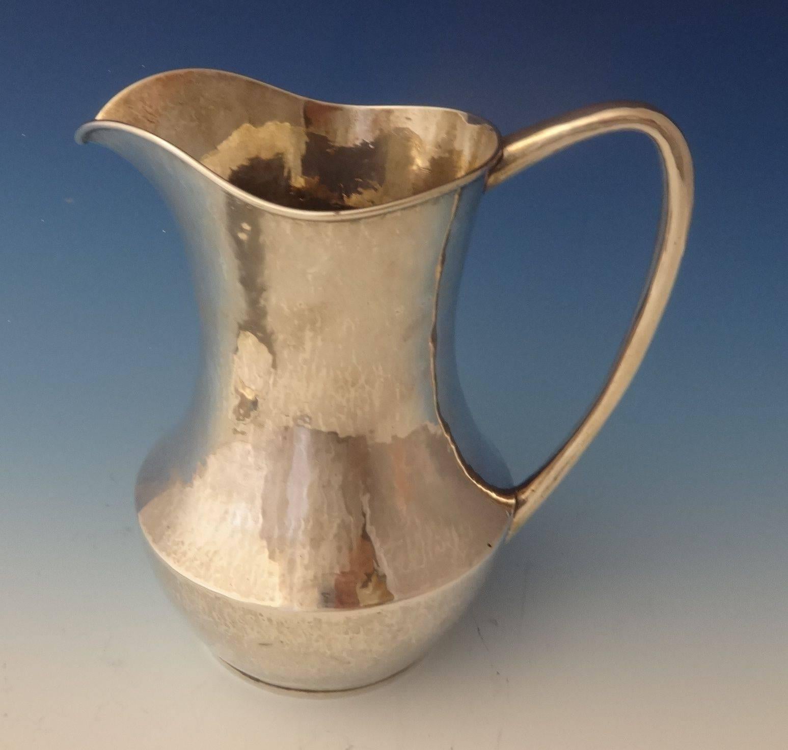 Kalo. 
 
 This simple yet elegant sterling water pitcher was hand-wrought by The Kalo Shop of Chicago, IL. It is beautifully hand-hammered and comes with the underplate. The pieces date from the 1900-40's, and there is a monogram on the bottom that