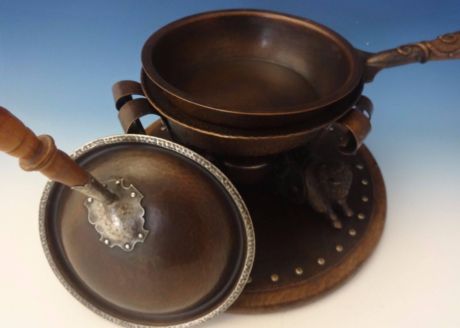 This rare Arts & Crafts silver and copper chafing dish was handmade by Joseph Heinrichs. This piece features three 3-D buffalo with a copper and sterling pot. It has applied copper on wood handles. It also includes an underplate with wood