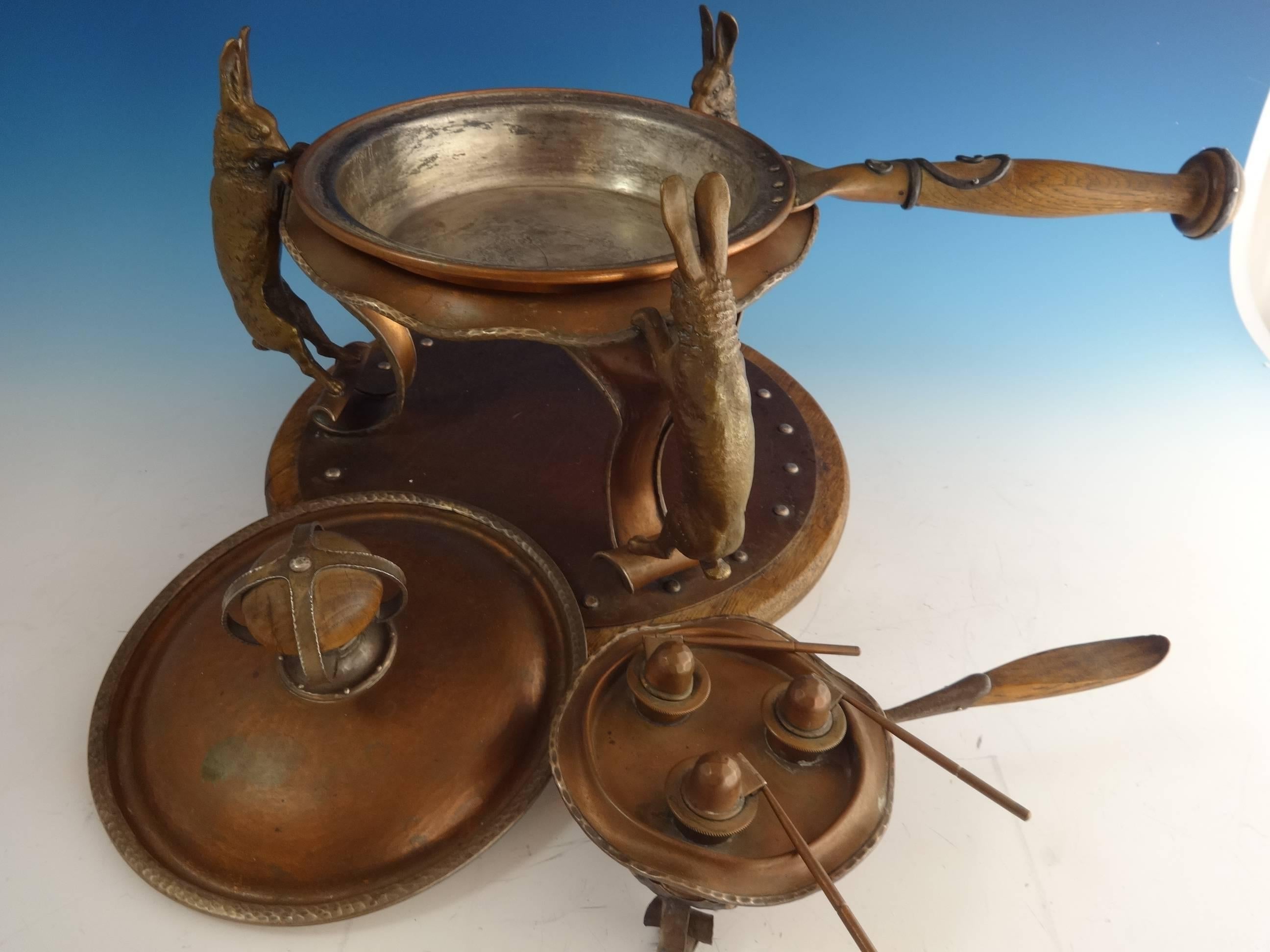 Arts & Crafts chafing dish made by Joseph Heinrichs featuring fabulous 3-D rabbits. The chaffing dish is made of copper with applied silver scrollwork on the wood handle and finial. It also includes the stand and burner. The piece measures