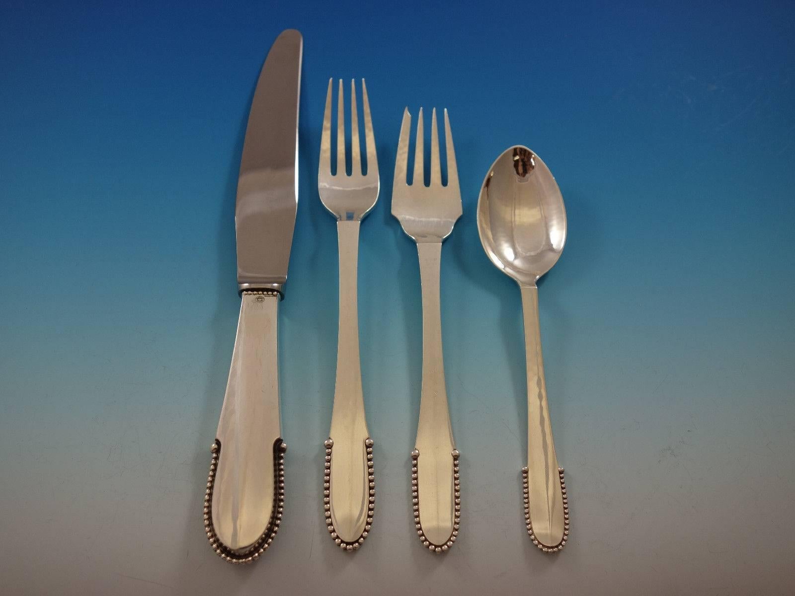 Beaded by Georg Jensen sterling silver flatware dinner set of 74 pieces. This set includes: 12 dinner knives, short wide handle, 8 7/8", 12 dinner forks, 7 1/8", 12 salad forks, 6 3/4", 12 teaspoons, 5 7/8", 12 tea knives, 6