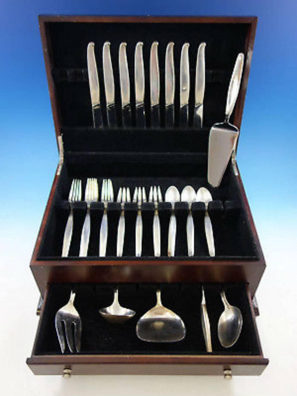 Contour by Towle Mid-Century Modern sterling silver flatware set, 38 pieces. This pattern has unique knives with blades set on an angle and smooth, fluid lines. This set includes: 

eight knives, 8 3/4