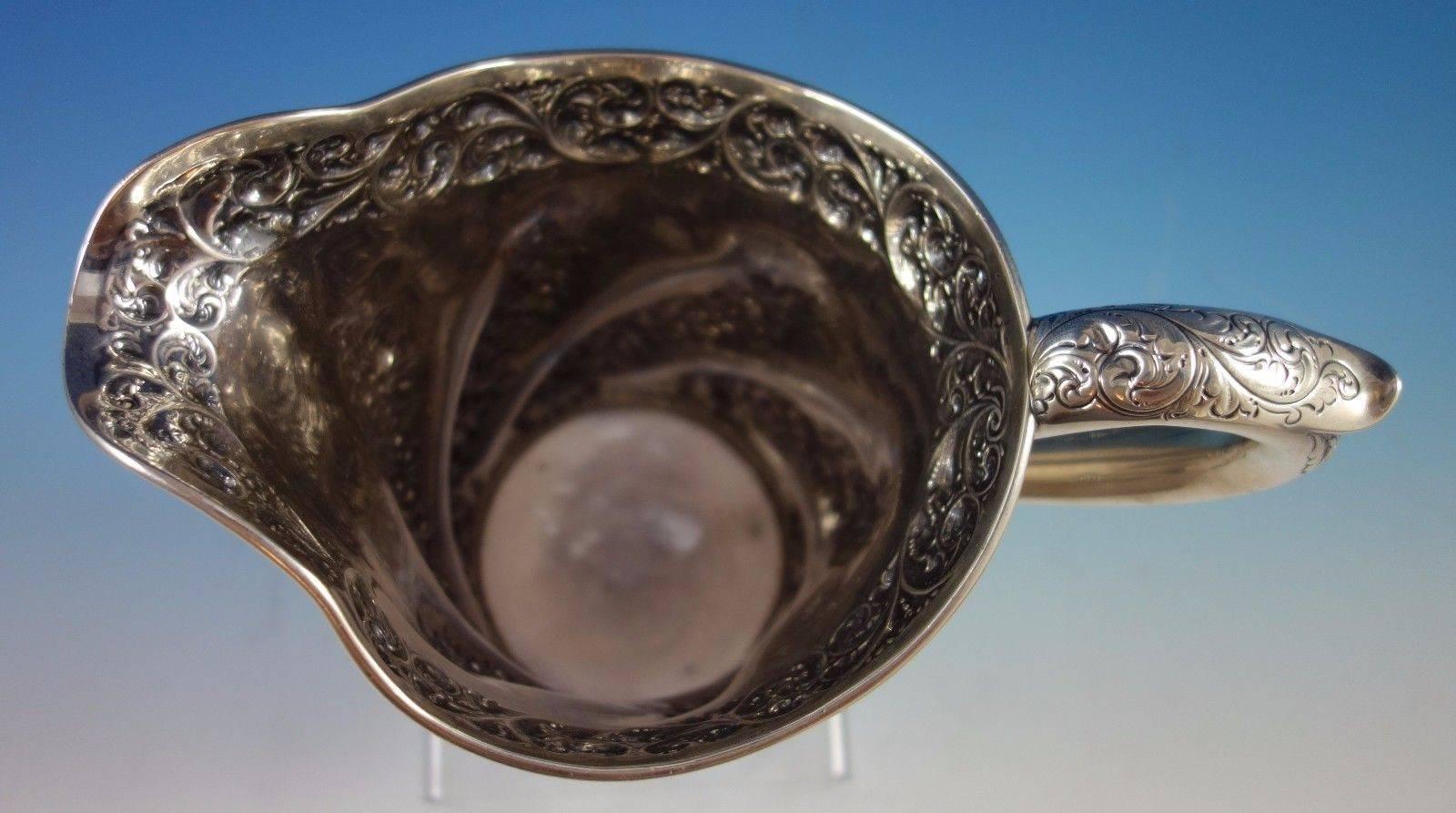 Lovely Gorham sterling silver water pitcher marked #1775. This piece weighs 24.13 troy ounces and measures 8 1/2" x 9". It features repousse flowers, hand chased scrollwork, and chased handle. There is a scrolly vintage monogram and it is