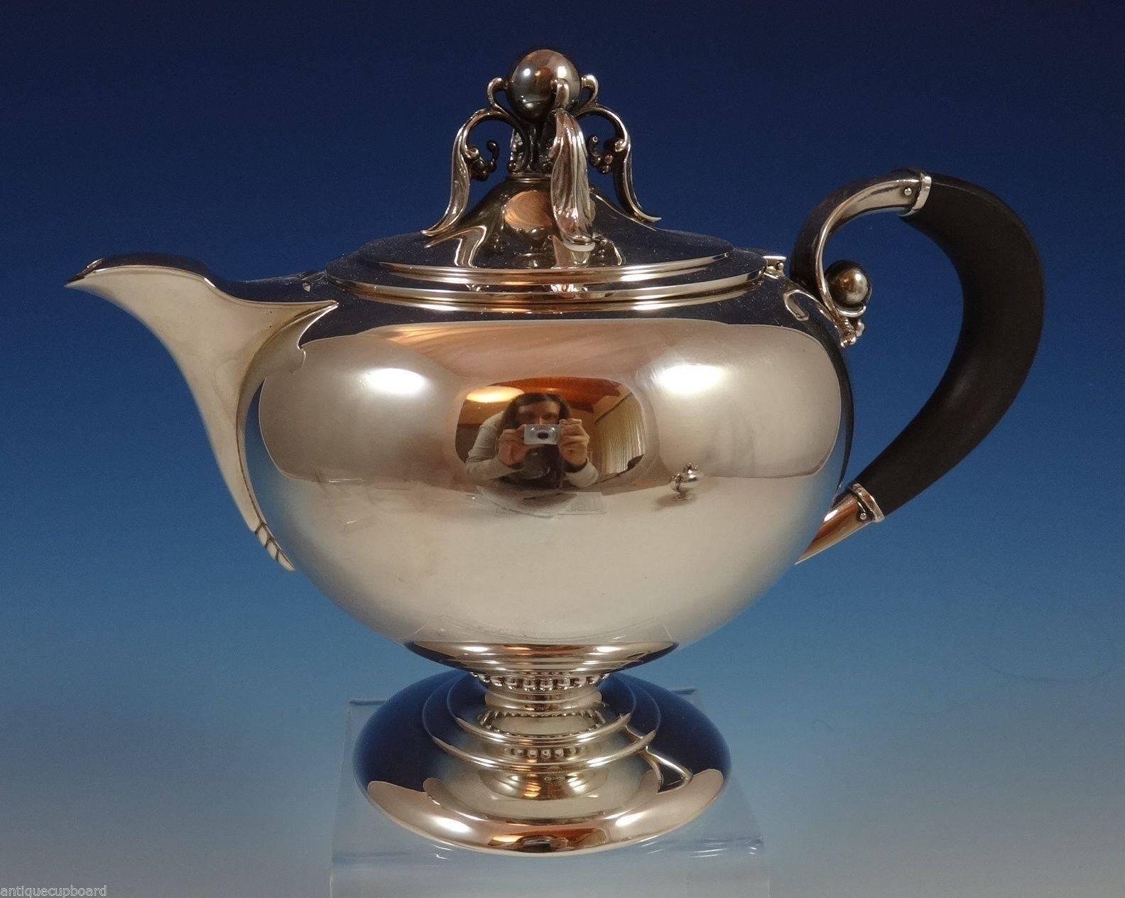 Modernism sterling silver five-piece tea set marked #600 made by M. Fred Hirsch Co. of New Jersey, circa 1920-1945. The tea set features 3-D cast ball and leaf elements on the finial and by the ebony handles. The set includes:

Coffee pot: Measures