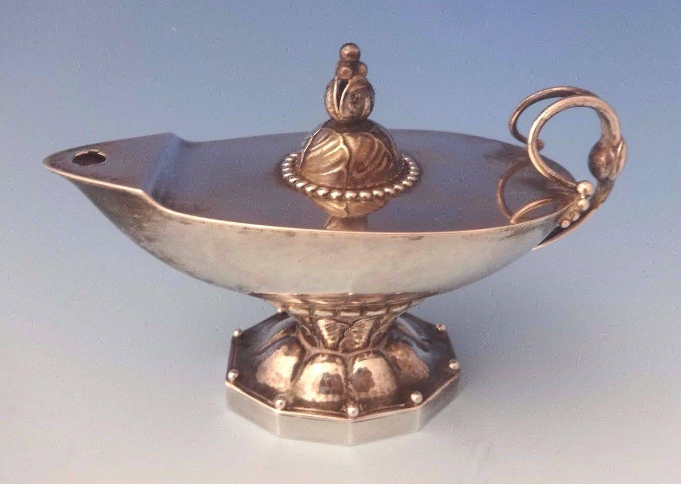 Georg Jensen.
Sterling silver Arts & Crafts Aladdin oil lamp style cigar lighter #12 with wonderful leaf and beaded detail by Georg Jensen. It has old GI marks and dates from 1915-1930. It is not monogrammed. It no longer has the flame snuffer