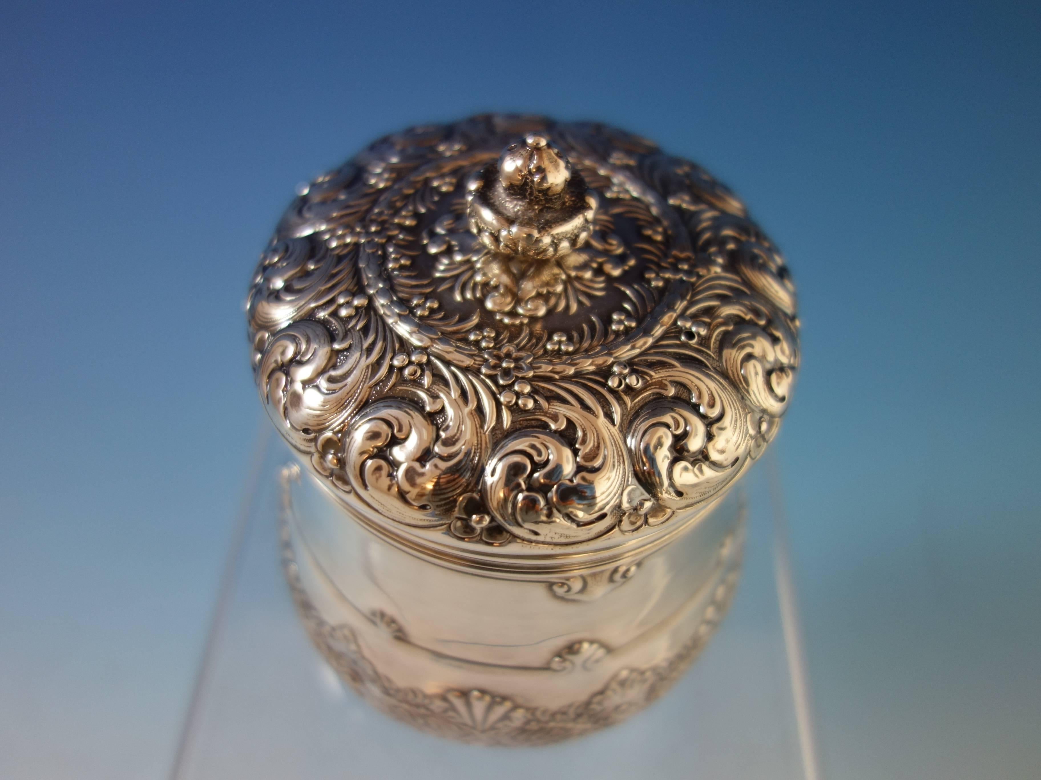 Tiffany and Co. sterling silver tea caddy with repoussed scrollwork and gold washed interior. This piece is marked #10444-9066 with a "T" date mark for 1892-1902. It weighs 7.45 troy ounces and measures 4 1/2" x 3 1/4". This