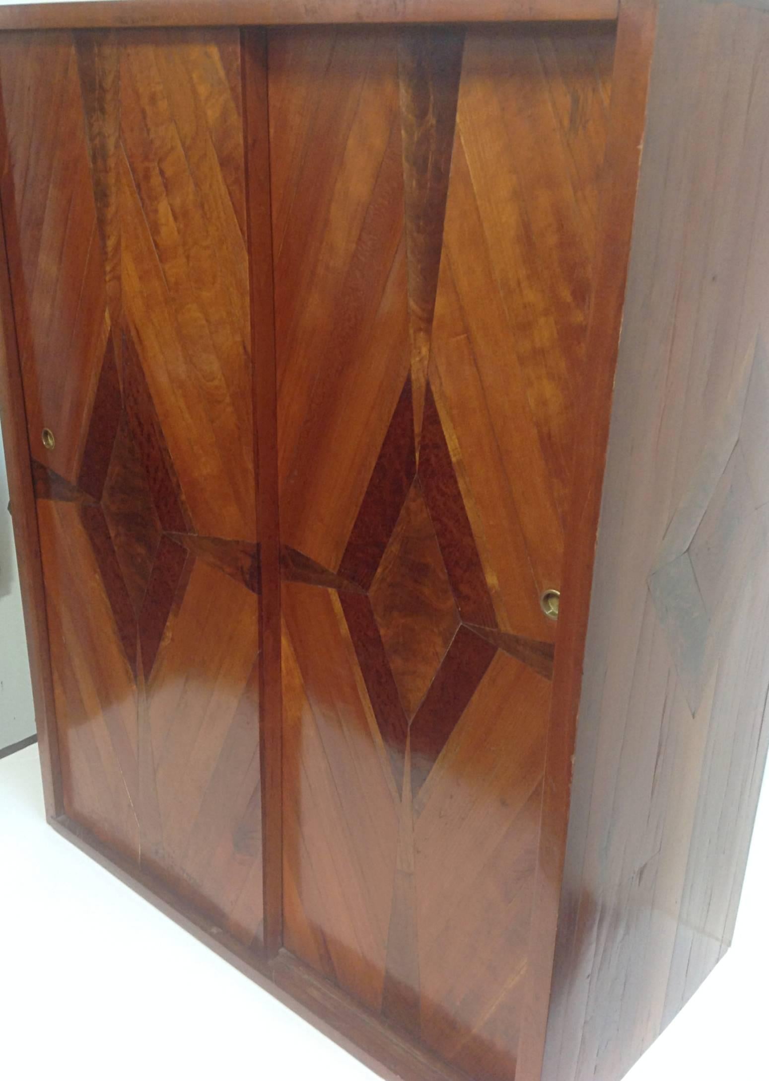 Bespoke hanging cabinet. Thick mixed fruit and hardwood veneers over pine case with solid cherry top. Neoclassical diamond details on sliding doors and side panels. Fixed interior shelves.