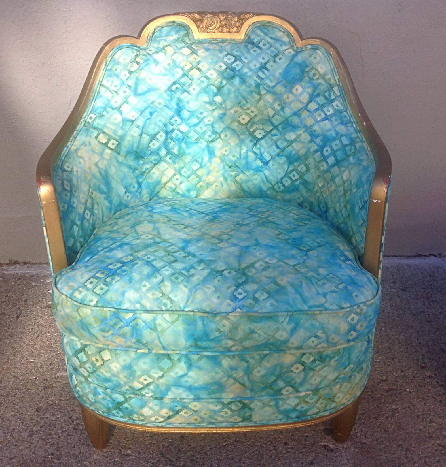 Art Deco lounge chair in the style of Paul Follot. Carved details in crest and feet of chair. Reeded details on Pouf feet. Down filled loose cushions on both the chair and ottoman. Age and wear present on gilt finish. Newly refurbished innards and