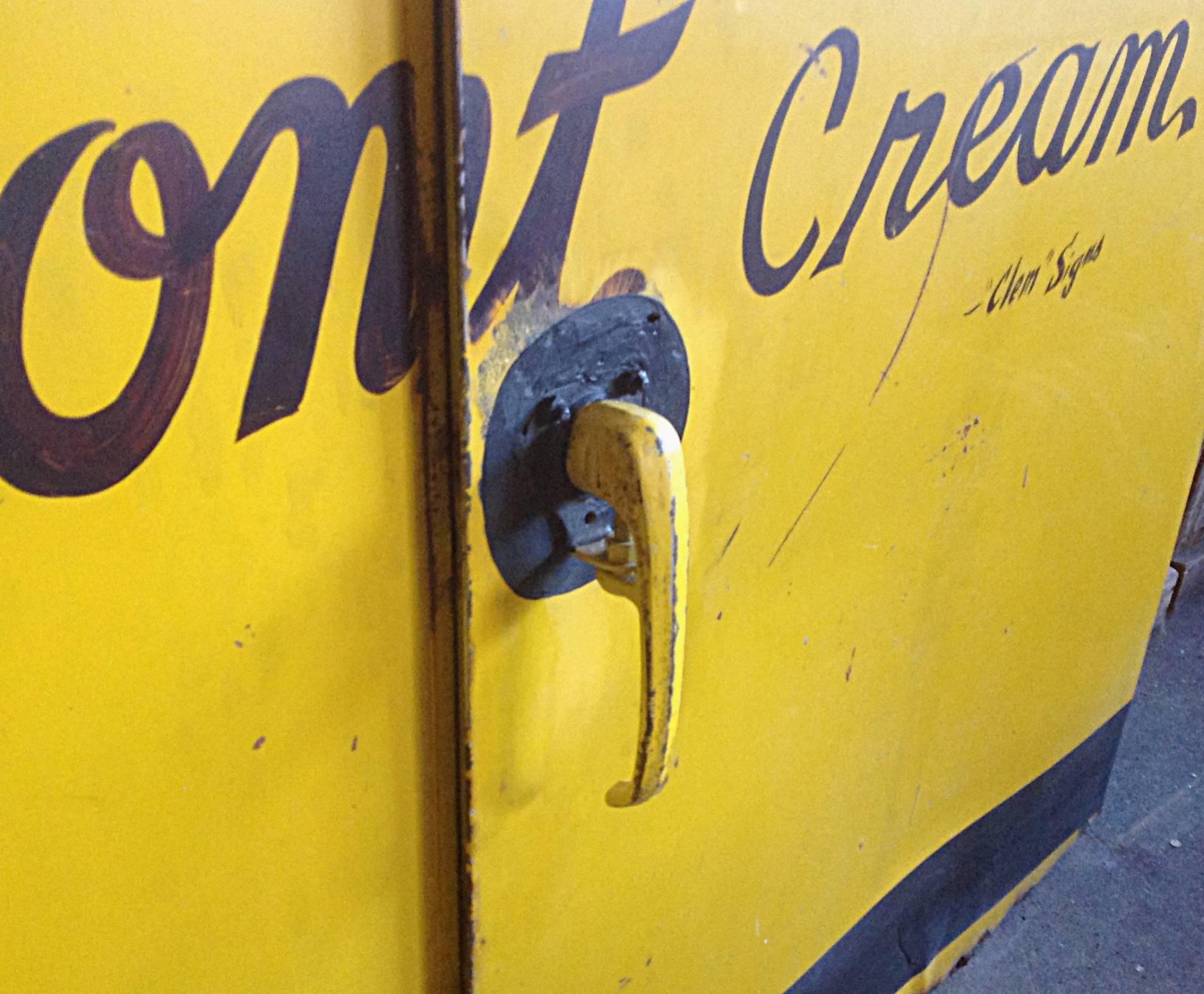 Spectacular pair of steel doors with hand lettered advertising. Malcolm T. Aikens was a Dairy man from Saratoga Springs, New York. Wonderful graphic lettering in black on vibrant yellow background, mid-20th century. Overall great condition some rust