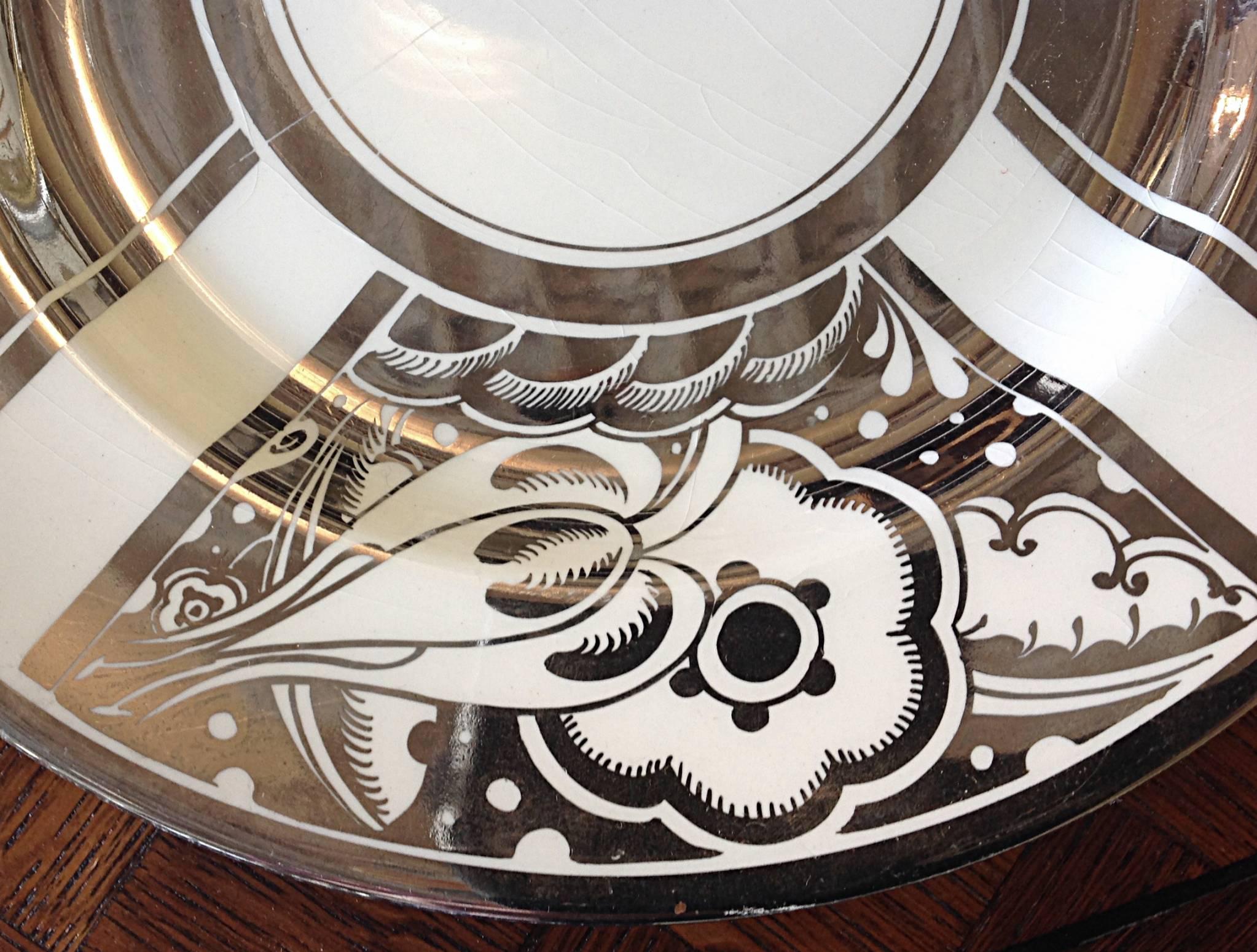 A wonderful set of Art Deco dinner plates. A Susie Cooper design from 1926 and produced in 1930. Platinum transfer ware. Very good condition with minor ware to platinum and crazing throughout. Artist signed and produced by Gray's Pottery of England.