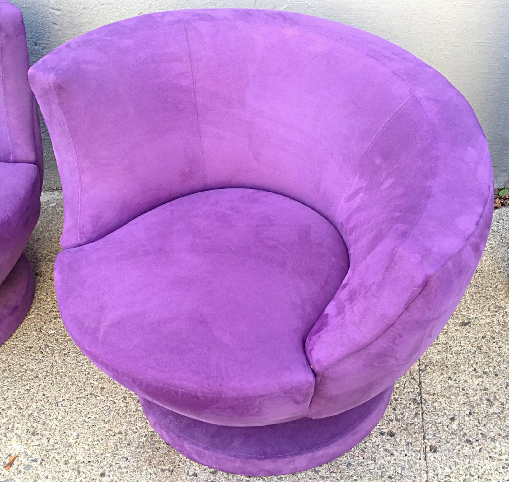 A wonderful pair of swivel chairs by Directional consisting of a right and left chair executed in a purple grape ultra-suede. A modified Nautilus chair with upholstered base and memory swivel function. Very good condition, minor wear.