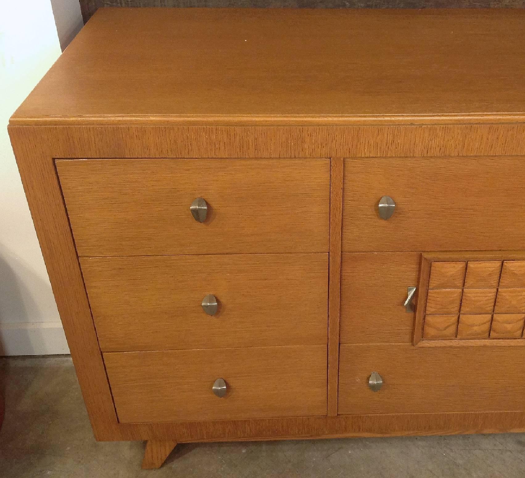 An elegant chest of drawers in riff cut and combed oak. Most likely American paying homage to the french designers of the 1940s like Gaston Poisson, Rene Gabriel and Charles Dudouyt. Top two center bank of drawers have fitted interiors. Modernist