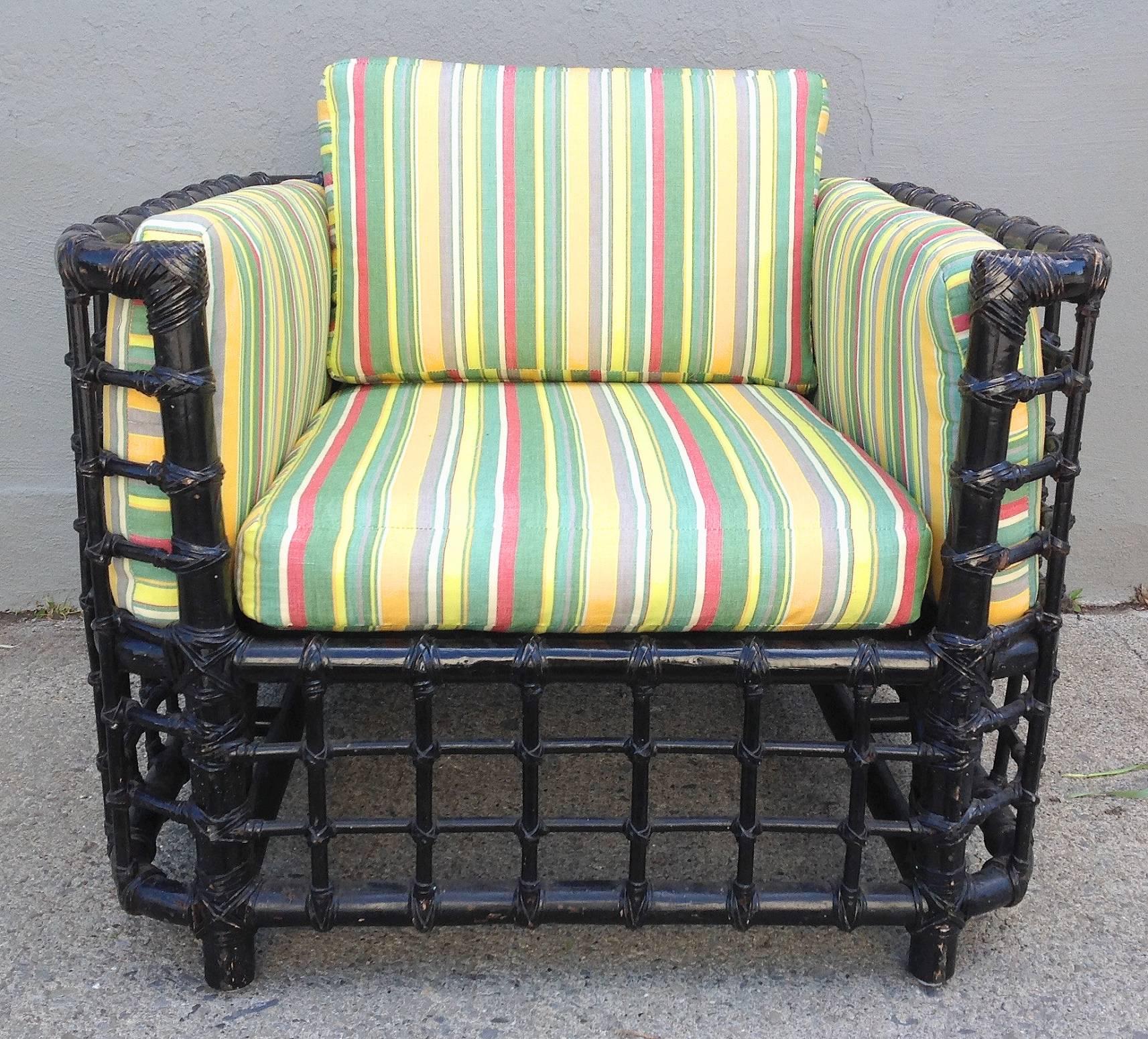 Stylish pair of black bamboo cube form lounge chairs. Woven in wide grid pattern with rounded corners. New cotton striped upholstery. Minor age, appropriate wear to paint finish. Most likely made by McGuire in the 1960s-1970s. Loveseat also
