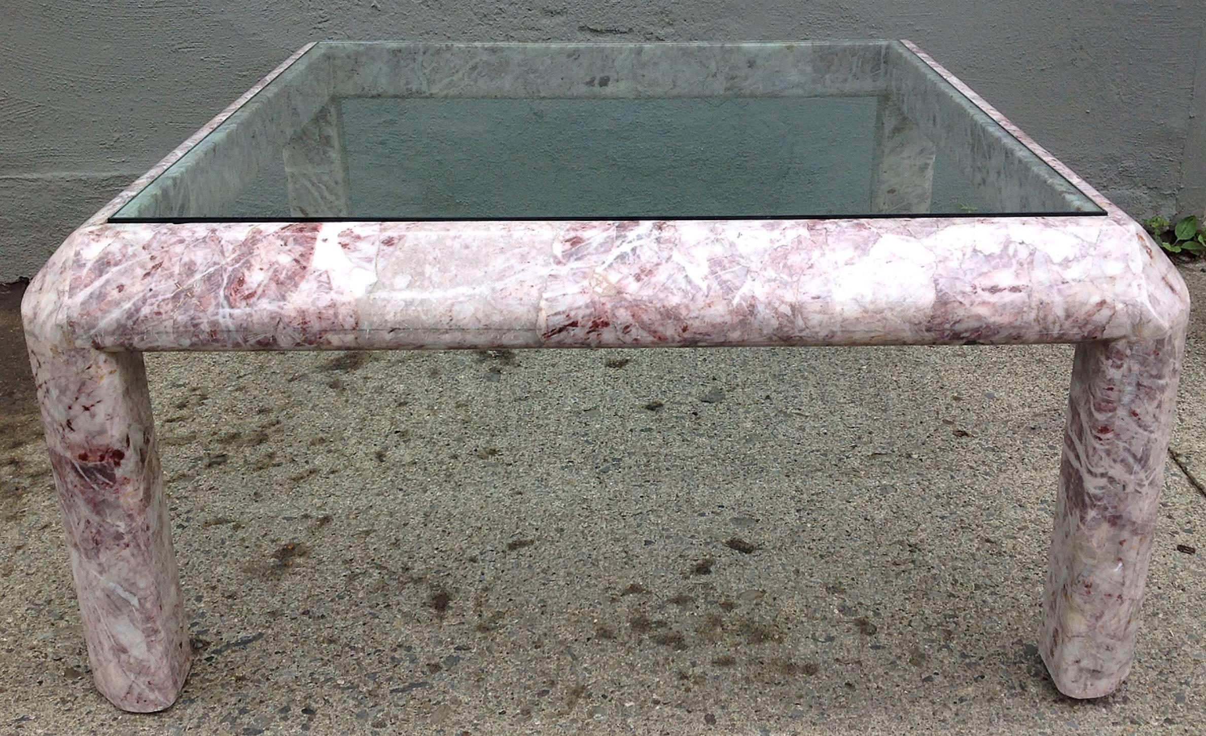A beautifully figured marble table with hues of pinks, reds and violets. Shaped legs and apron with beveled corners. Recessed smoked glass top.